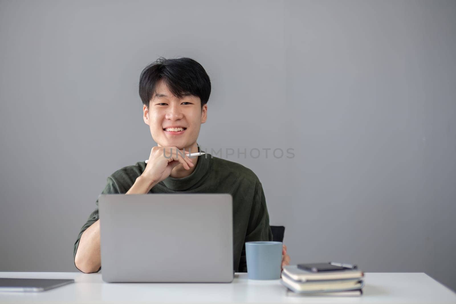Portrait of a handsome young office worker intently studying how to do a presentation project on a laptop in his office. by wichayada