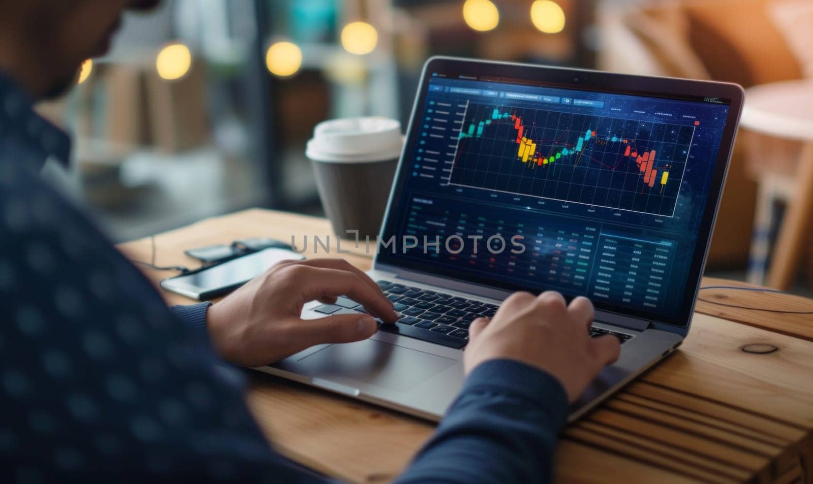 Close up of trader using his laptop to make profits remotely in a coffee shop by papatonic