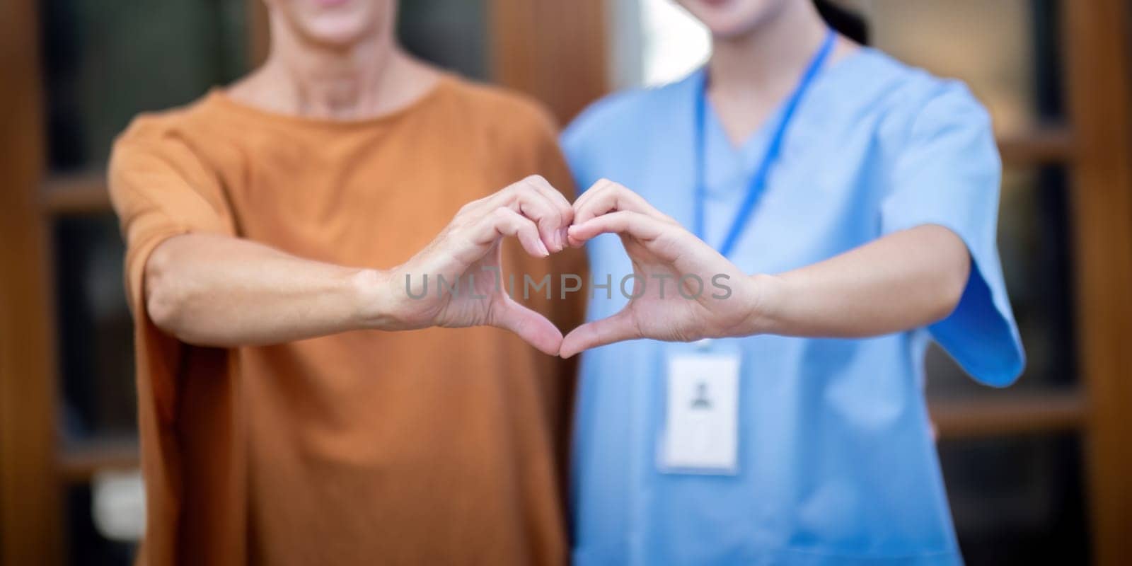 Nurse or caregiver and elderly woman support, healthcare service and health portrait at home. Medical physiotherapy, make a heart shape with your hands together in home by nateemee