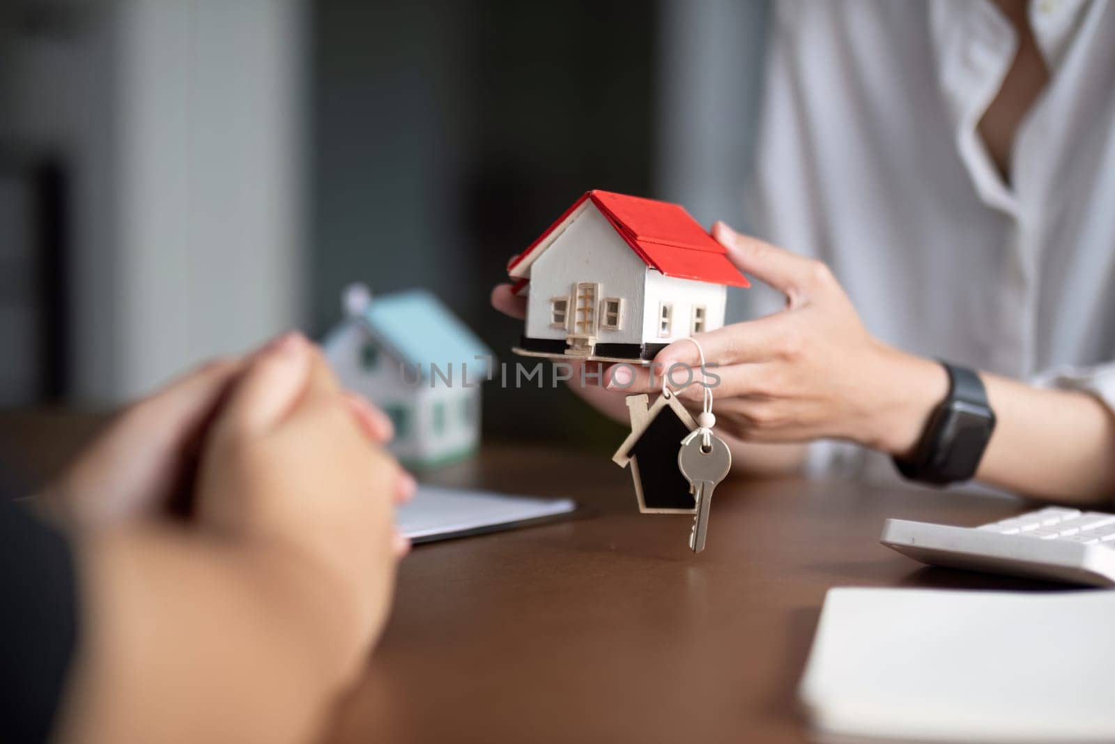 Real estate agent hand over property or new home keys to a customer.