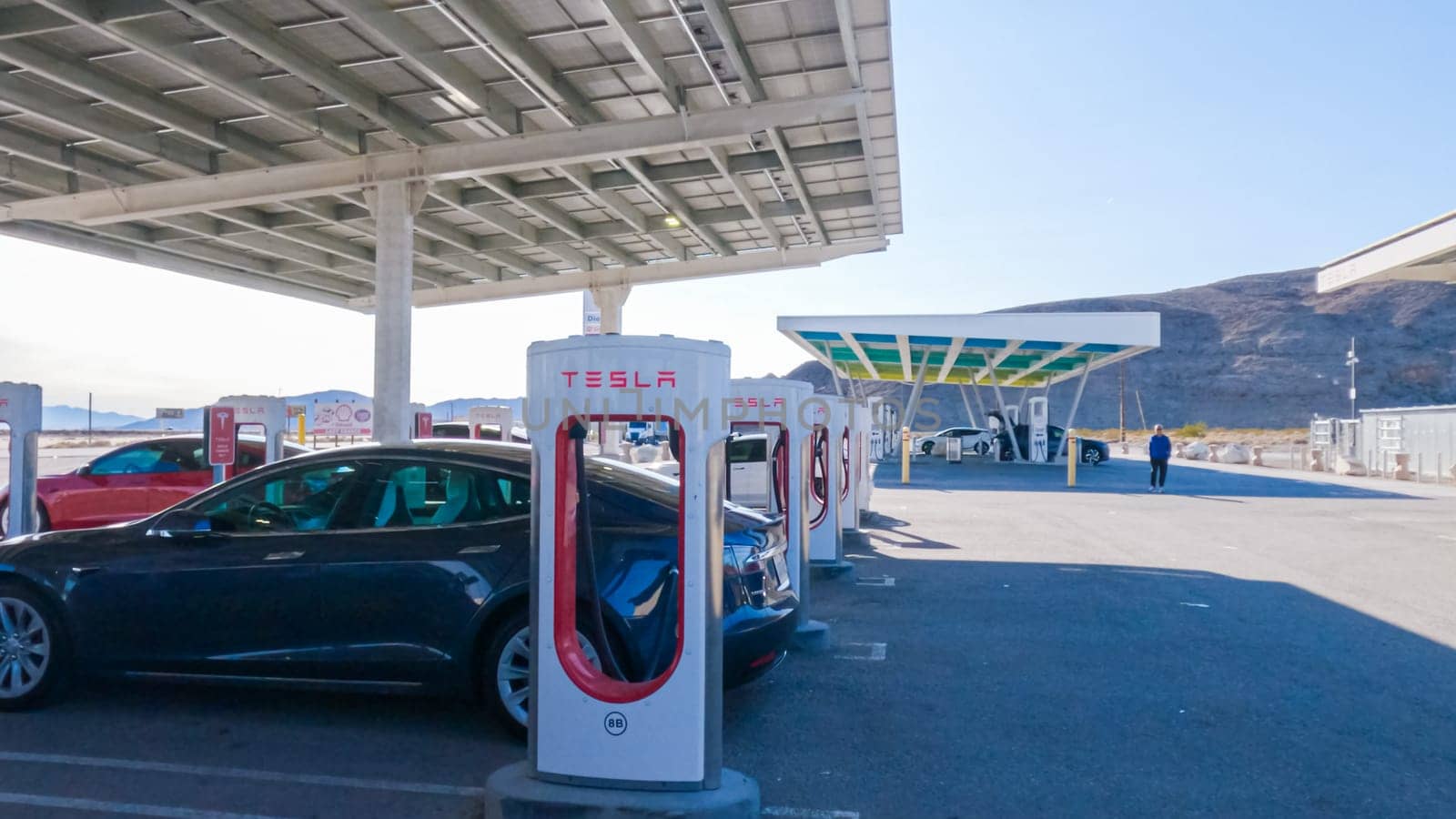 Baker, California, USA-December 3, 2022-During the day, a Tesla vehicle is seen charging at a Tesla Supercharging station, utilizing the high-speed charging infrastructure for convenient and efficient electric vehicle refueling.