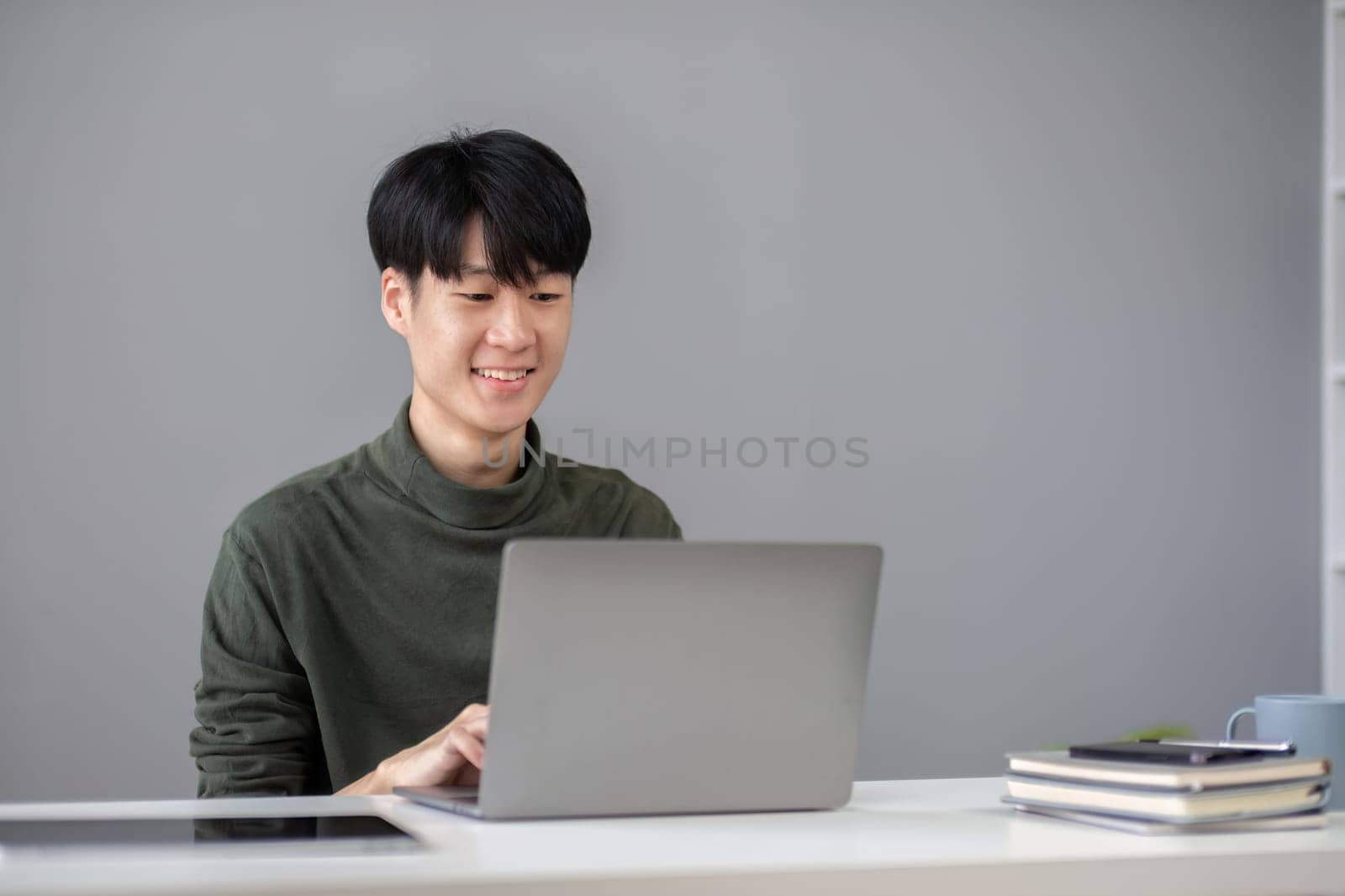 Portrait of a handsome young office worker intently studying how to do a presentation project on a laptop in his office..