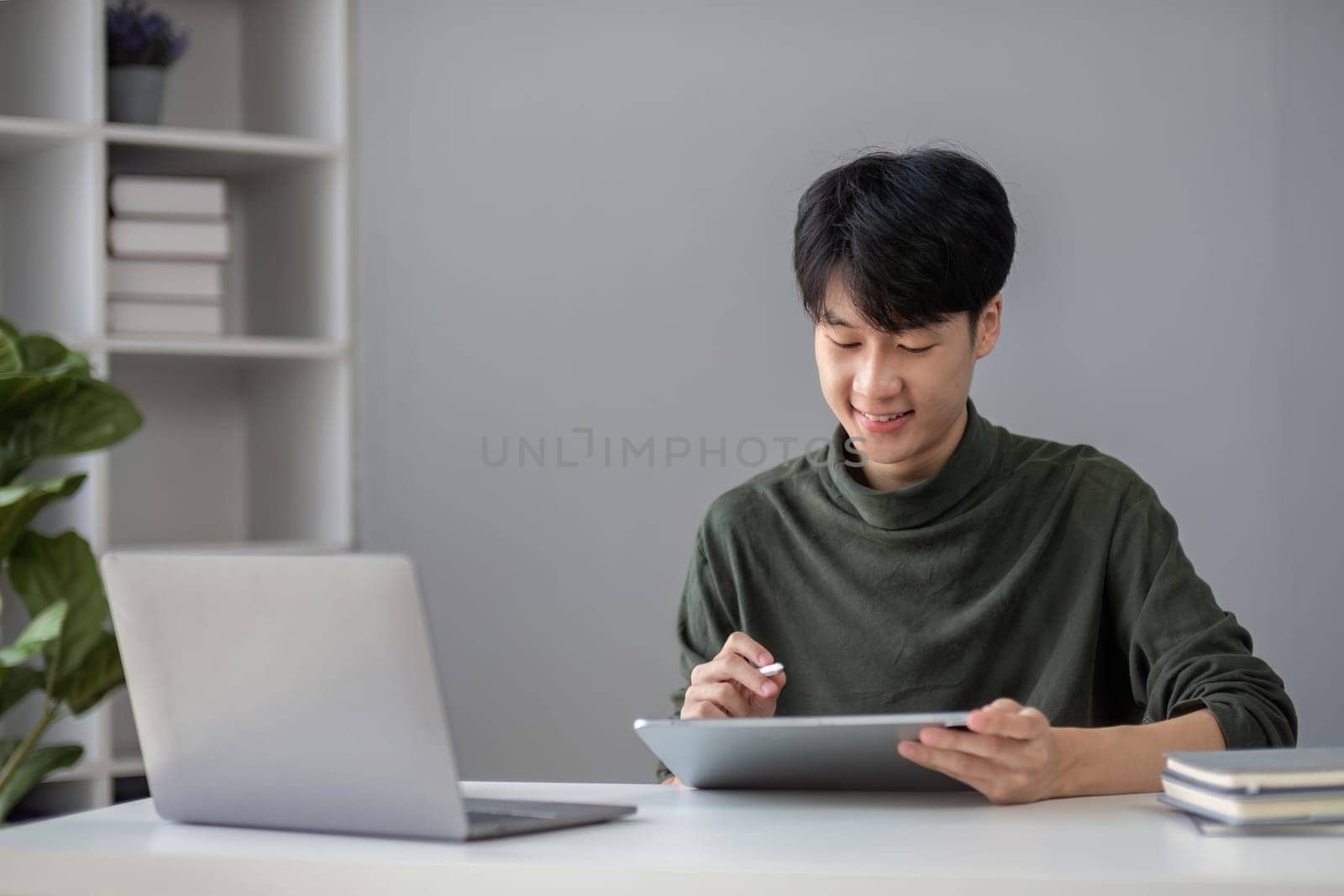 Portrait of a handsome young office worker intently studying how to do a presentation project on a laptop in his office..