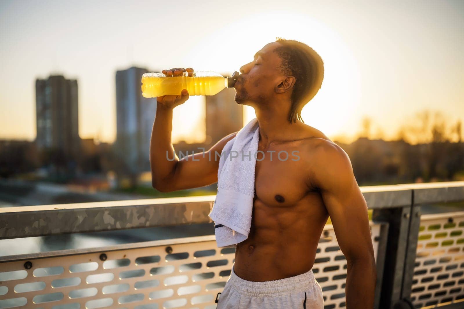 Portrait of y  man who is drinking water and relaxing after jogging by djoronimo