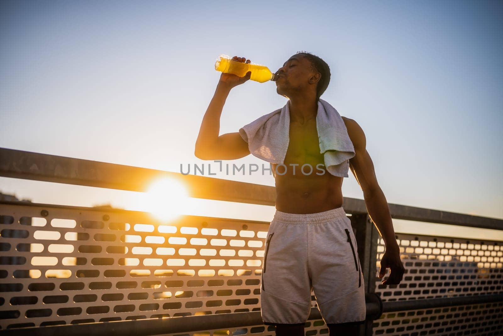 Young man who is drinking water and relaxing after jogging by djoronimo