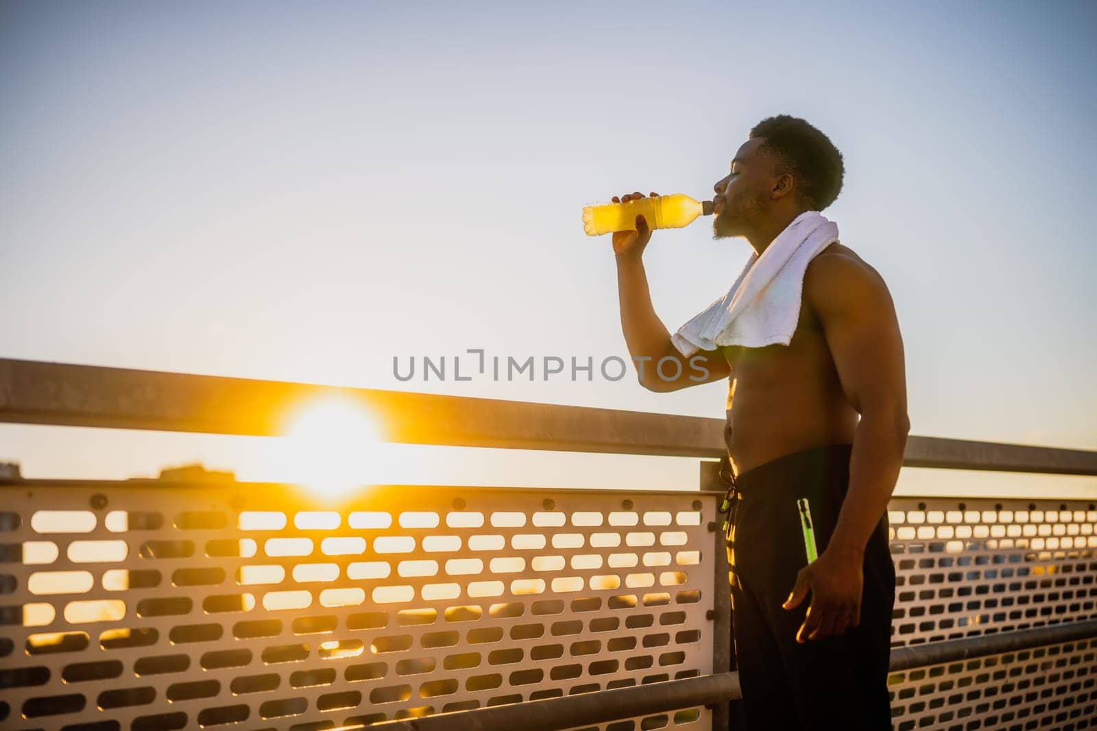 Young  man  is drinking water and relaxing after jogging by djoronimo