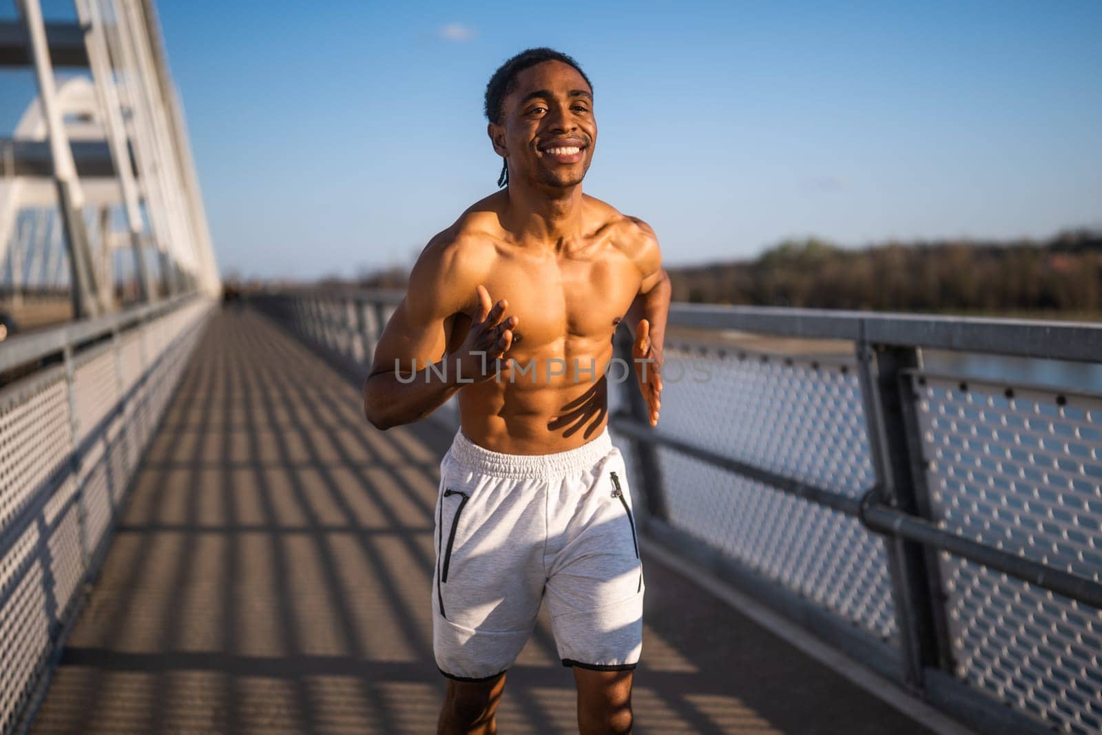 Young  man is jogging on the bridge in the city.