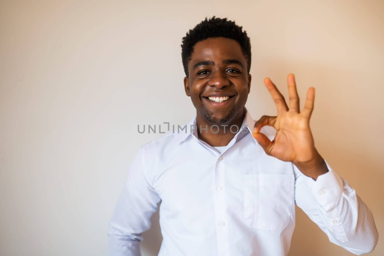 Portrait of happy man who is smiling and showing excellent sign by djoronimo