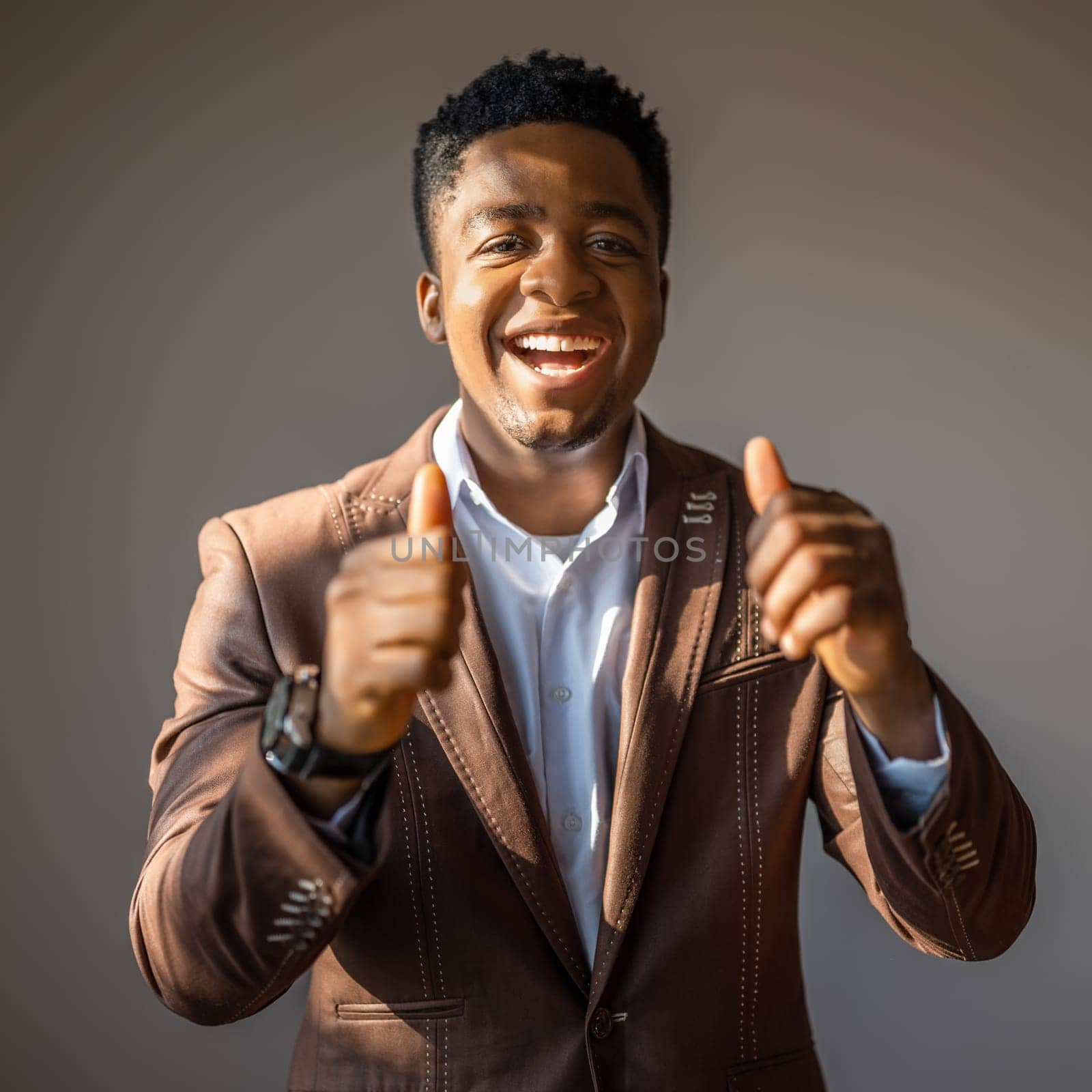 Portrait of happy businessman who is smiling and showing thumbs up.
