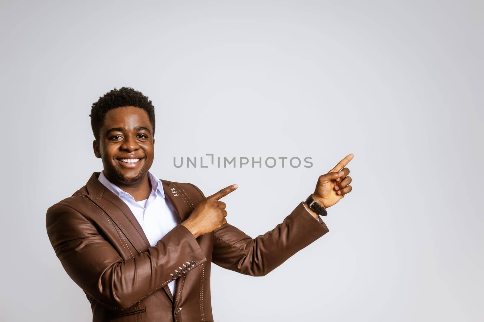 Portrait of happy businessman who is smiling and pointing at blank space on image. Copy space for your text or advert.