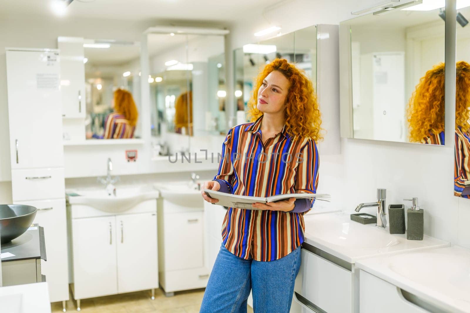 Portrait of buyer in bathroom store. Redhead woman is choosing equipment for her apartment.
