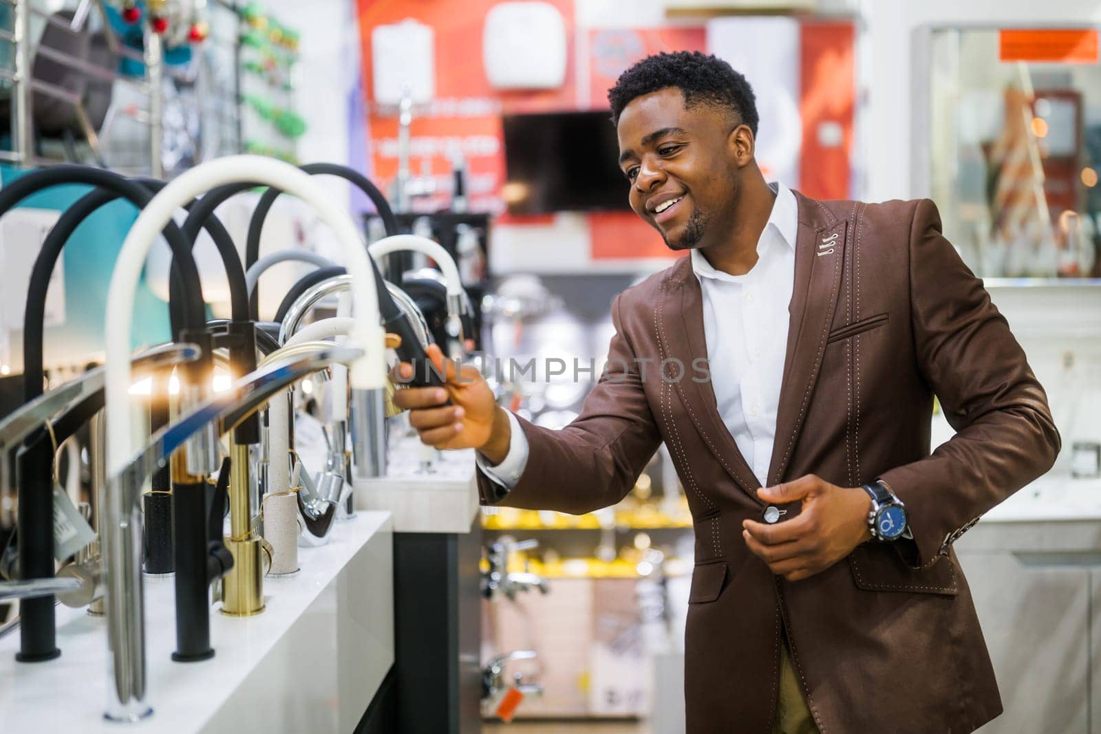 Portrait of buyer in bathroom store. Man is choosing faucet for his apartment.