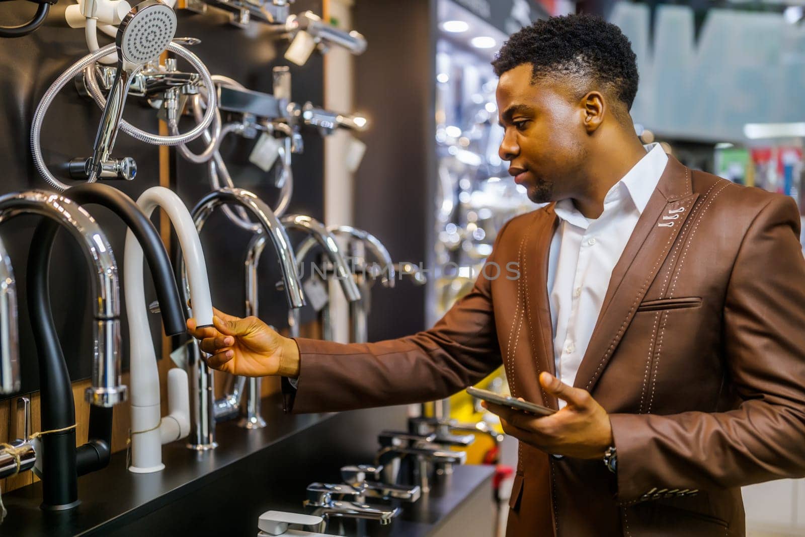 Portrait of buyer in bathroom store. Man is choosing faucet for his apartment.