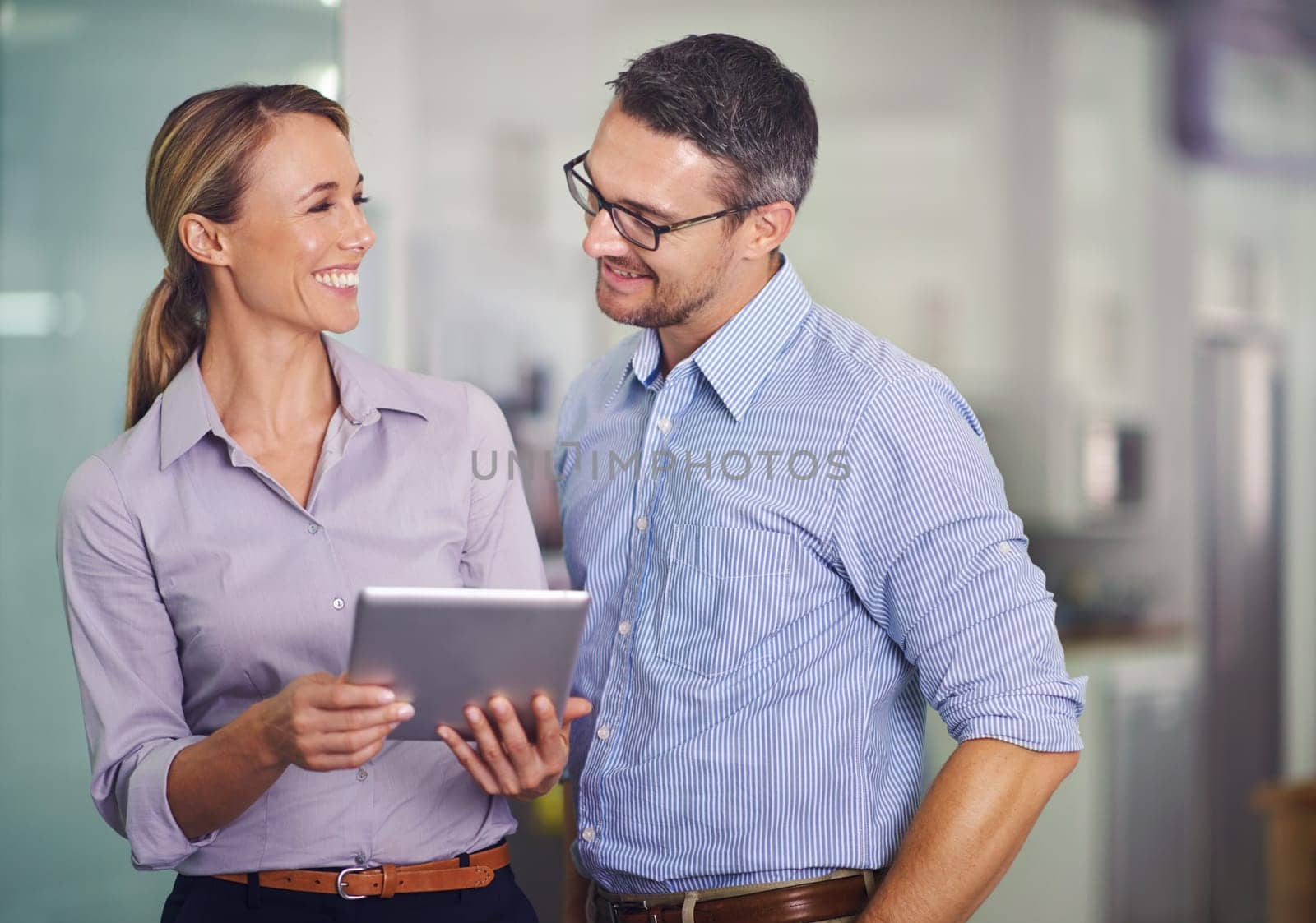 Happy, business people and team with tablet for research, communication or networking at the office. Businessman and woman with smile on technology for online search, browsing or app at the workplace by YuriArcurs