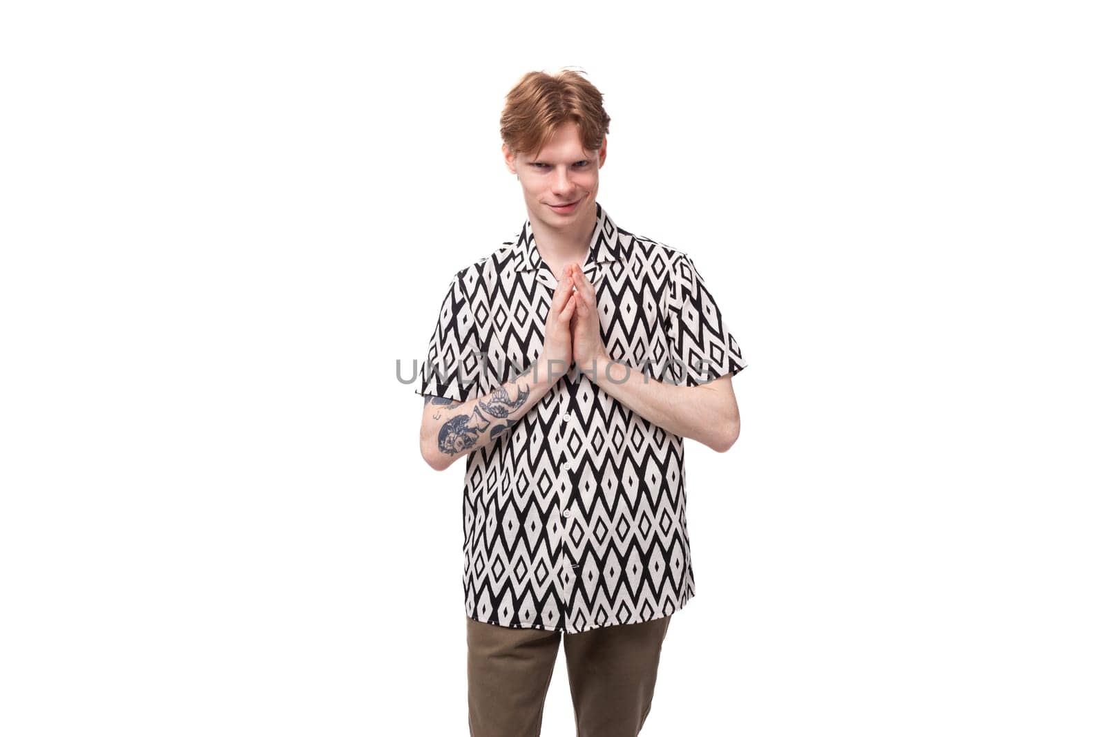 young stylish red-haired man dressed in a summer short-sleeved shirt in black and white.