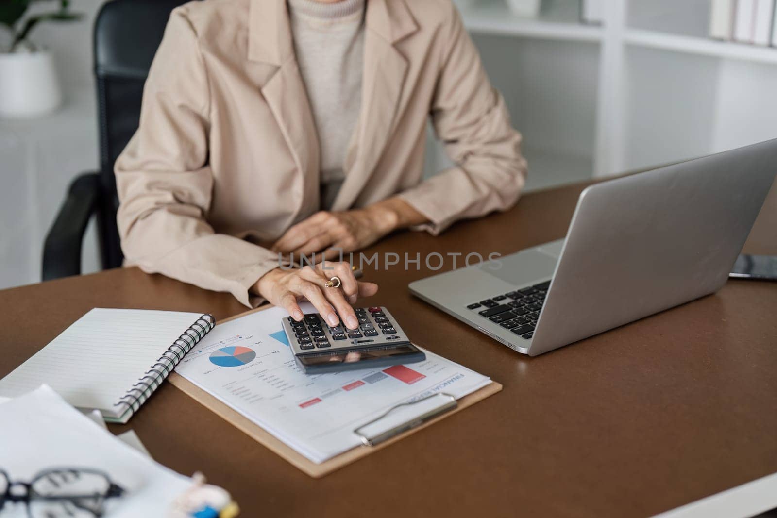 Business finance concept, Business woman using calculator to calculate business data at office by itchaznong