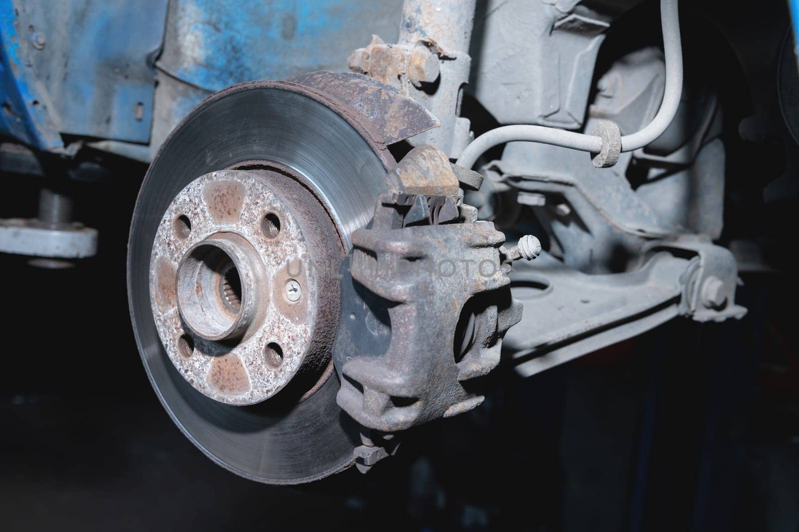 Rust protection and repair of a disk broken in a service center, close-up. Front suspension of an old car.