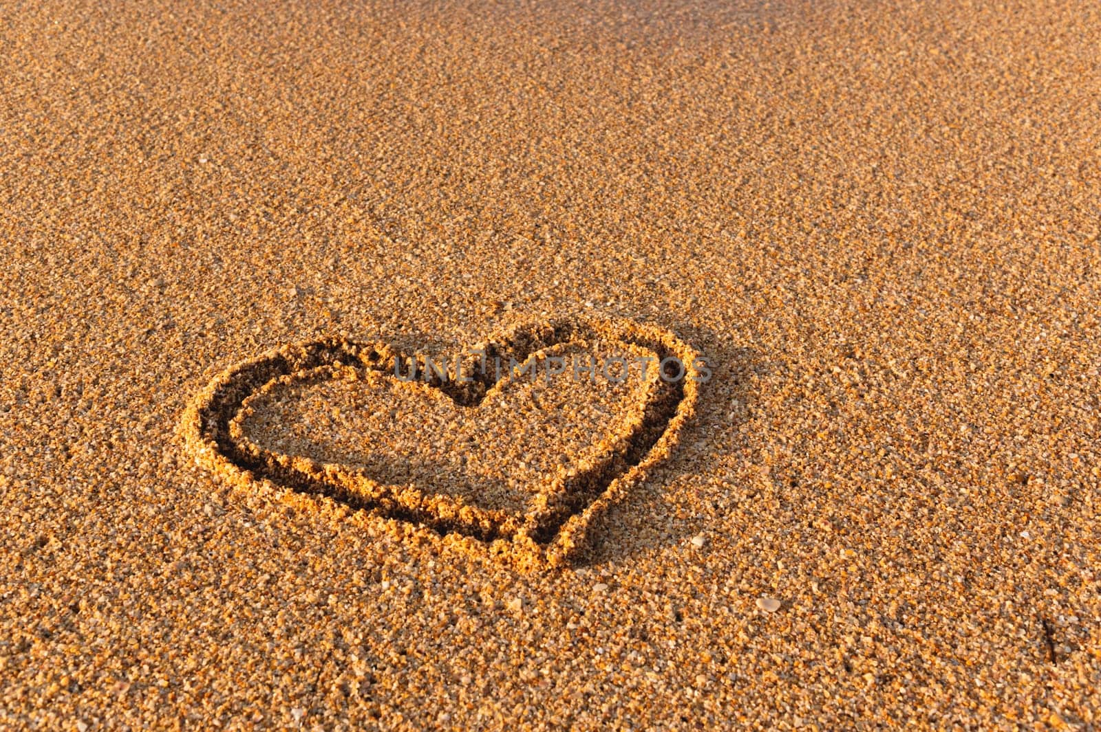 Heart drawn in the sand. Beach background. Top view by yanik88