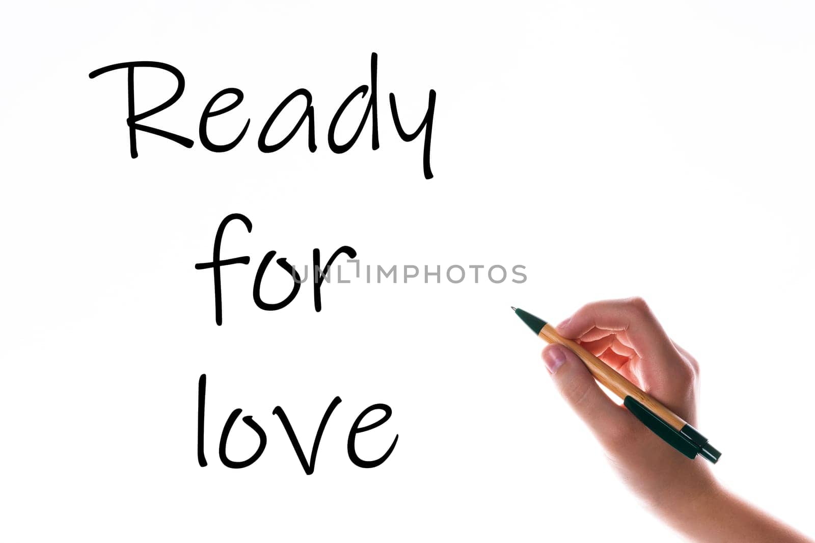 Children hand with pen write on an blue white background. Writing hand. Words Ready for love by Zelenin