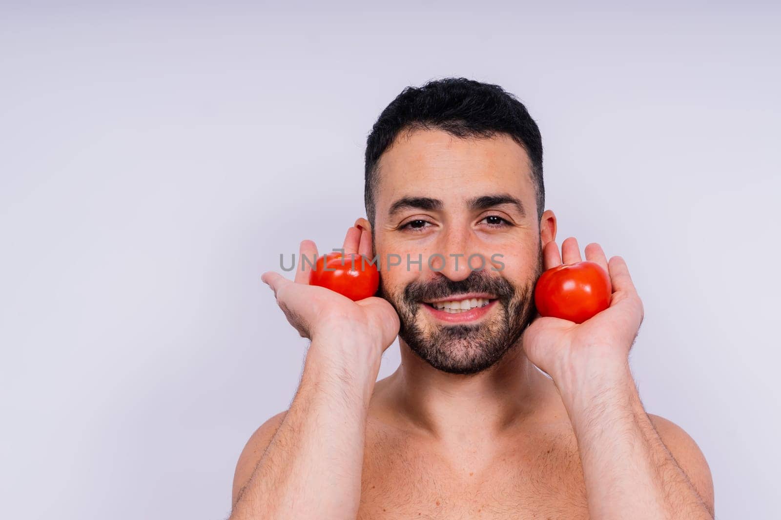 Full isolated studio picture from a young naked man with underwear and tomatoes