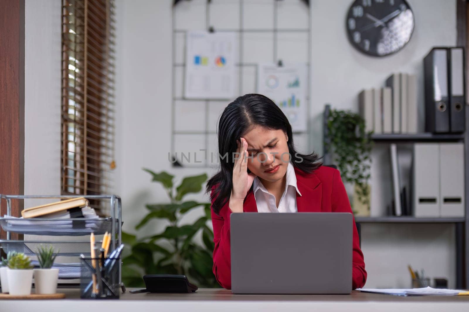 A determined businesswoman is sitting with stress in her home office..