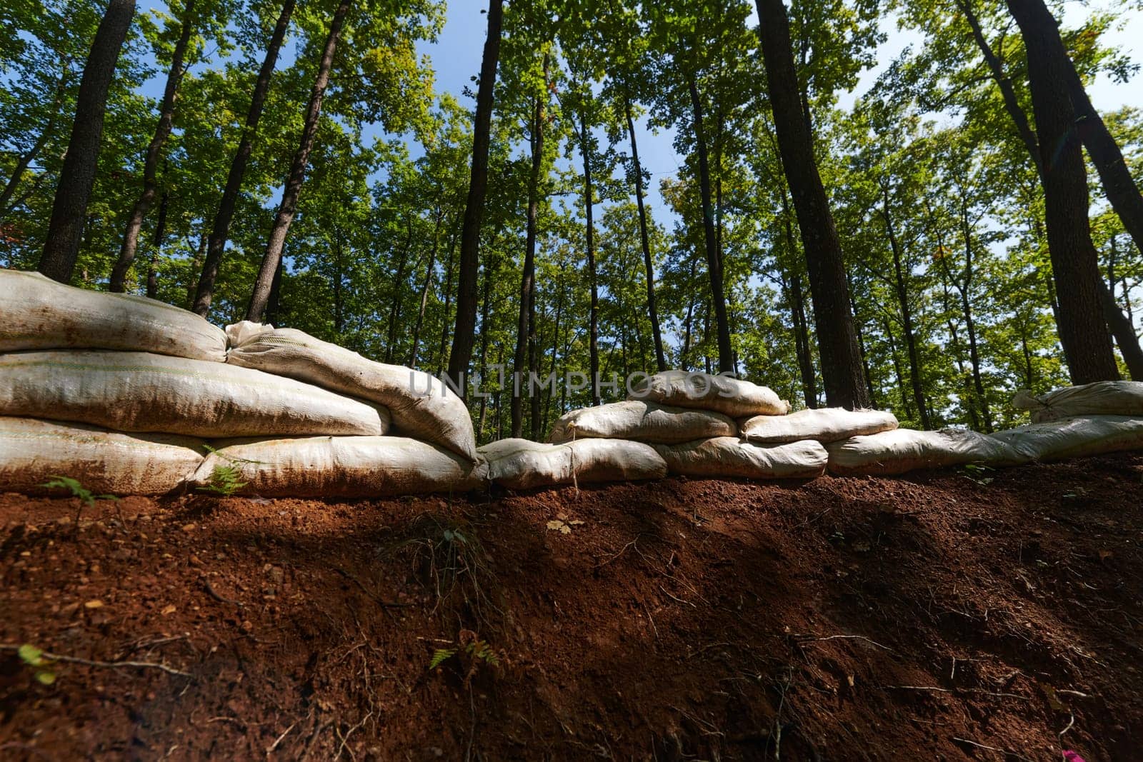 a military unit strategically employs sandbags as a defensive wall, creating a fortified barrier to enhance their safety and protection, showcasing the tactical use of simple yet effective measures in their encampment. by dotshock