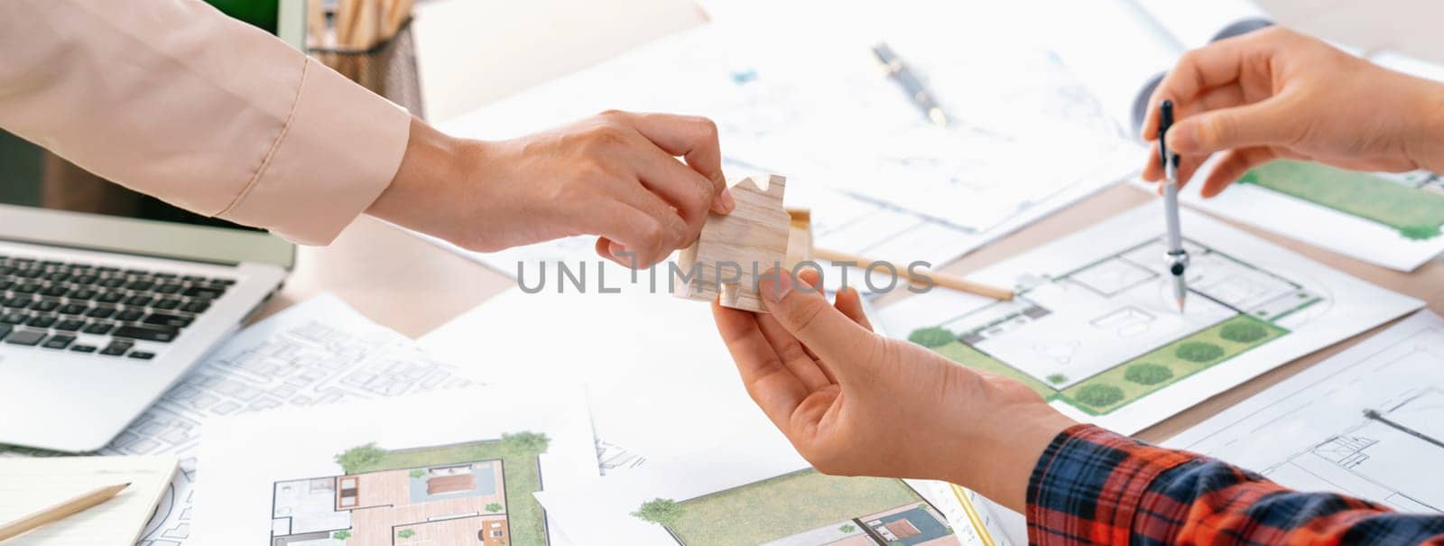 Professional engineer and architect collaborate on eco house project at meeting table with green design blueprint and architectural equipment at modern office. Focus on hand. Close up. Delineation.