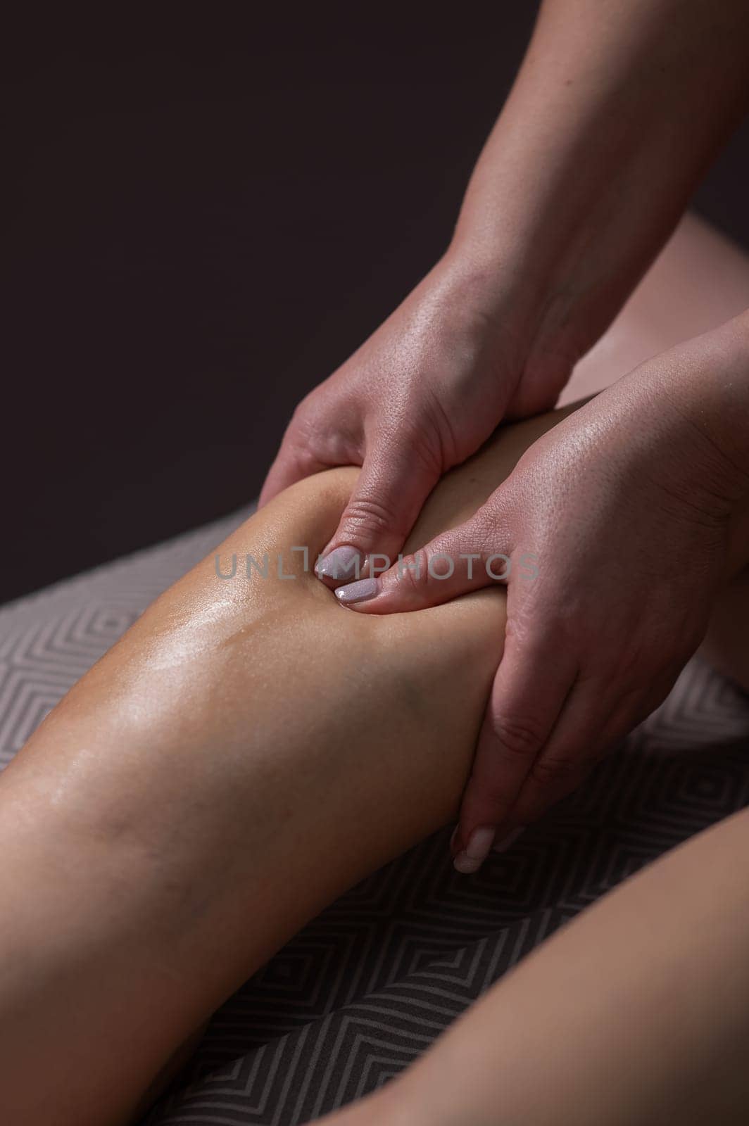Close-up of a woman's leg massage in a salon. Vertical photo. by mrwed54