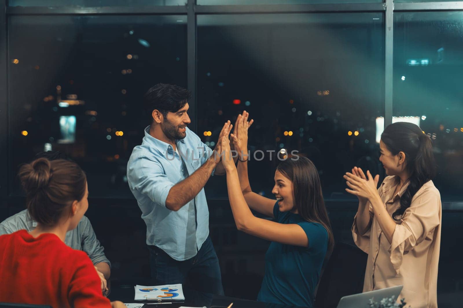 Successful businesspeople giving high five together while coworker clapping hands to celebrate successful project. Group of happy business people applause for getting promotion, bonus. Tracery.