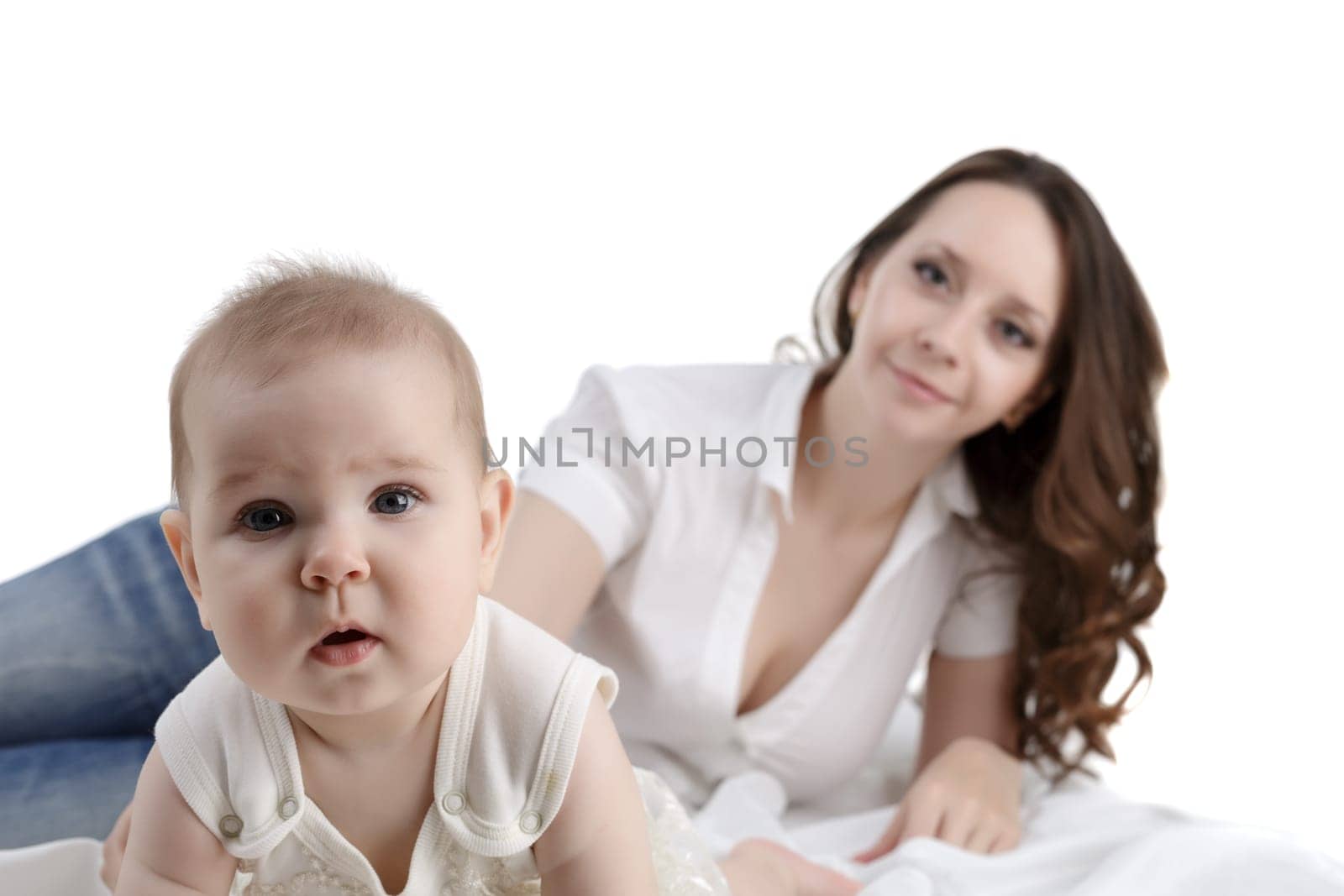 Adorable baby posing at camera and her mom on background