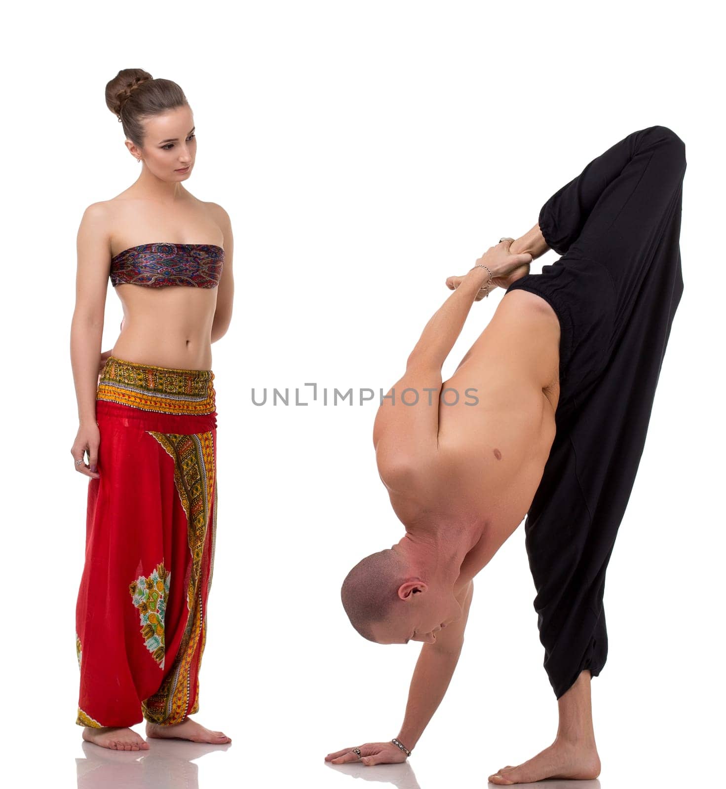 Brunette watches as yoga coach performs asana, isolated on white