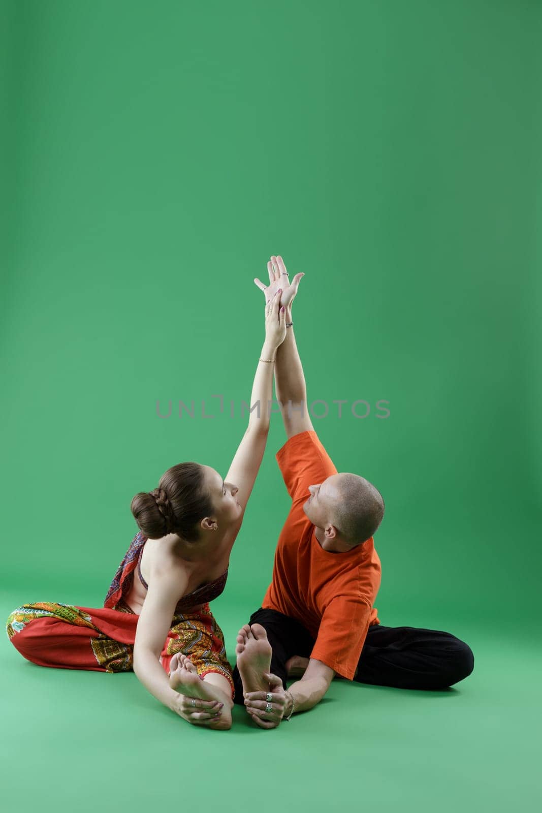 Yoga. Man and woman performing paired asana by rivertime