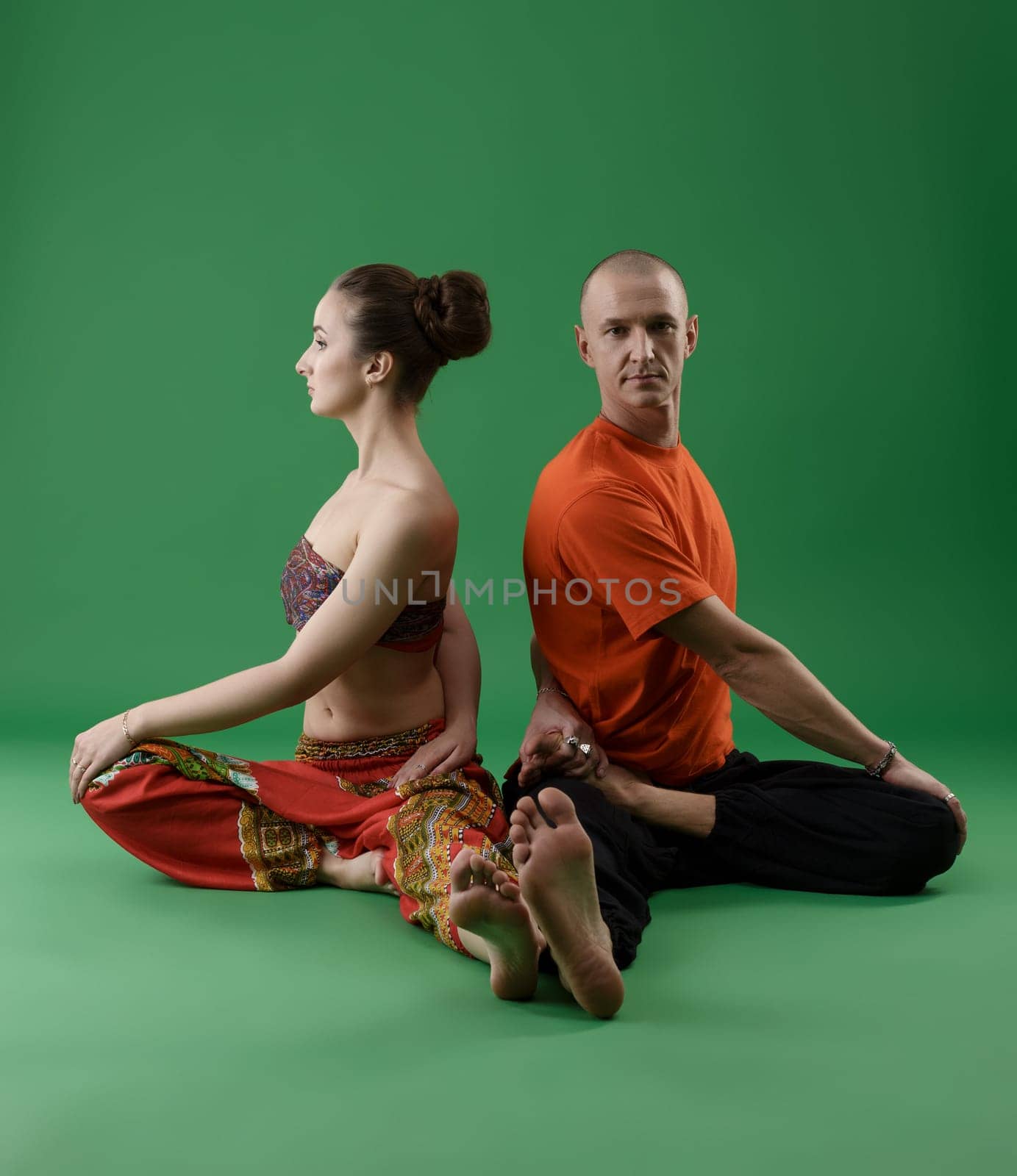 Man and woman practicing yoga in pair. Studio image