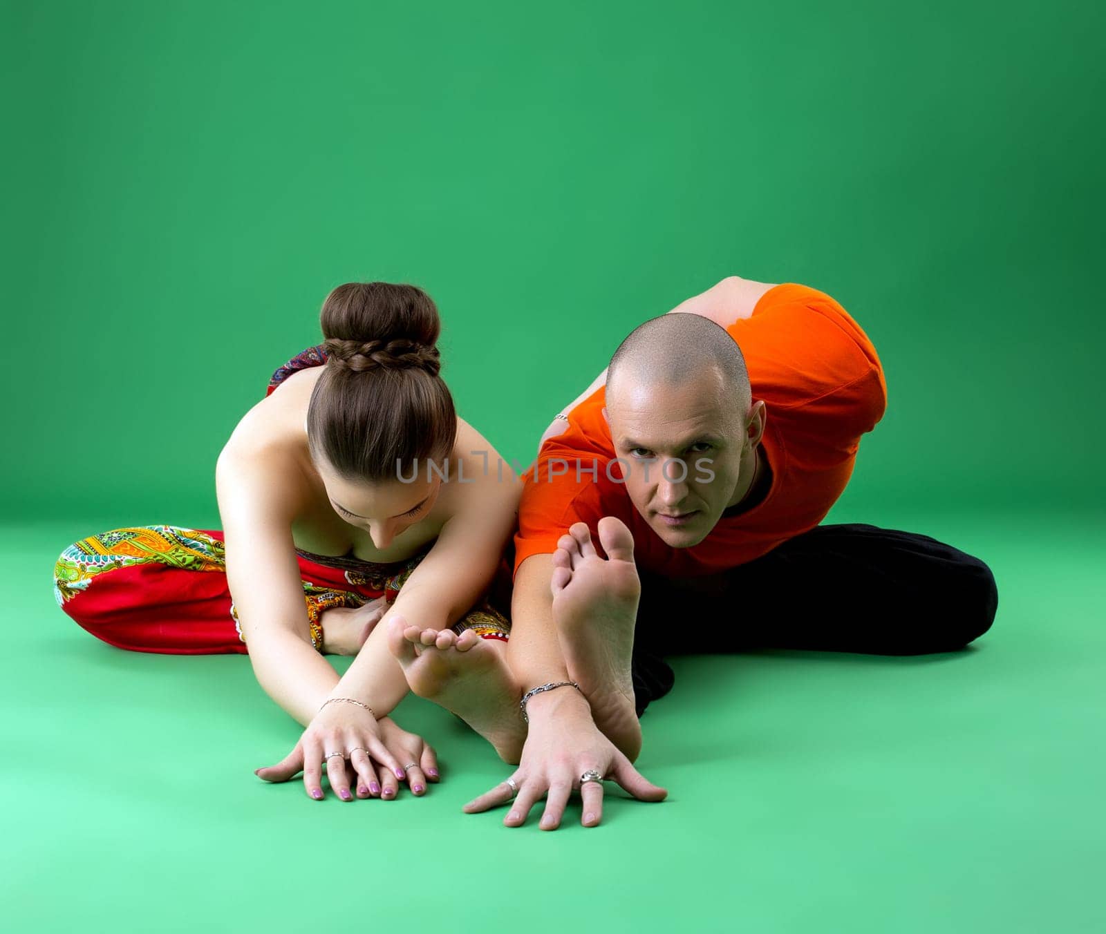 Paired yoga training. Instructor looking attentively at camera