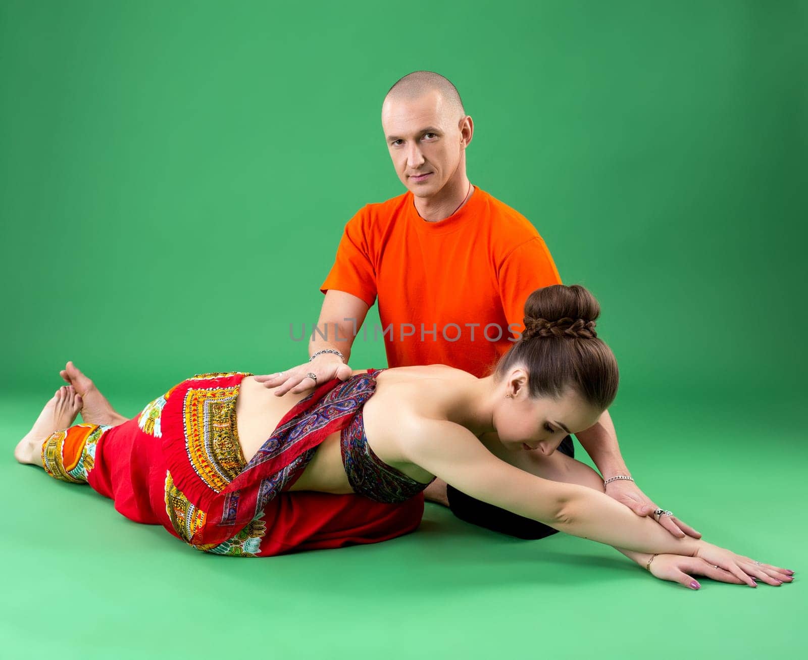 Yoga. Instructor helps woman to perform asana by rivertime