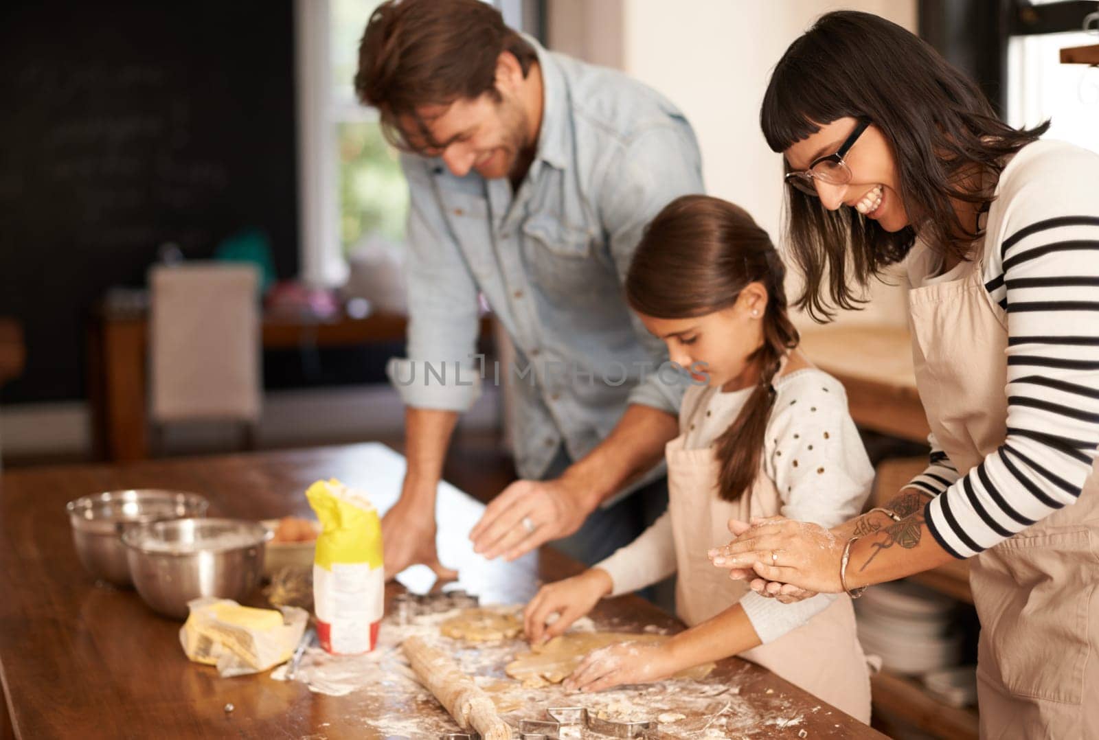 Mother, father and girl with baking cake in kitchen with oven, happiness and teaching with support. Family, parents and child with helping, learning and bonding with cooking for dinner and cookies.