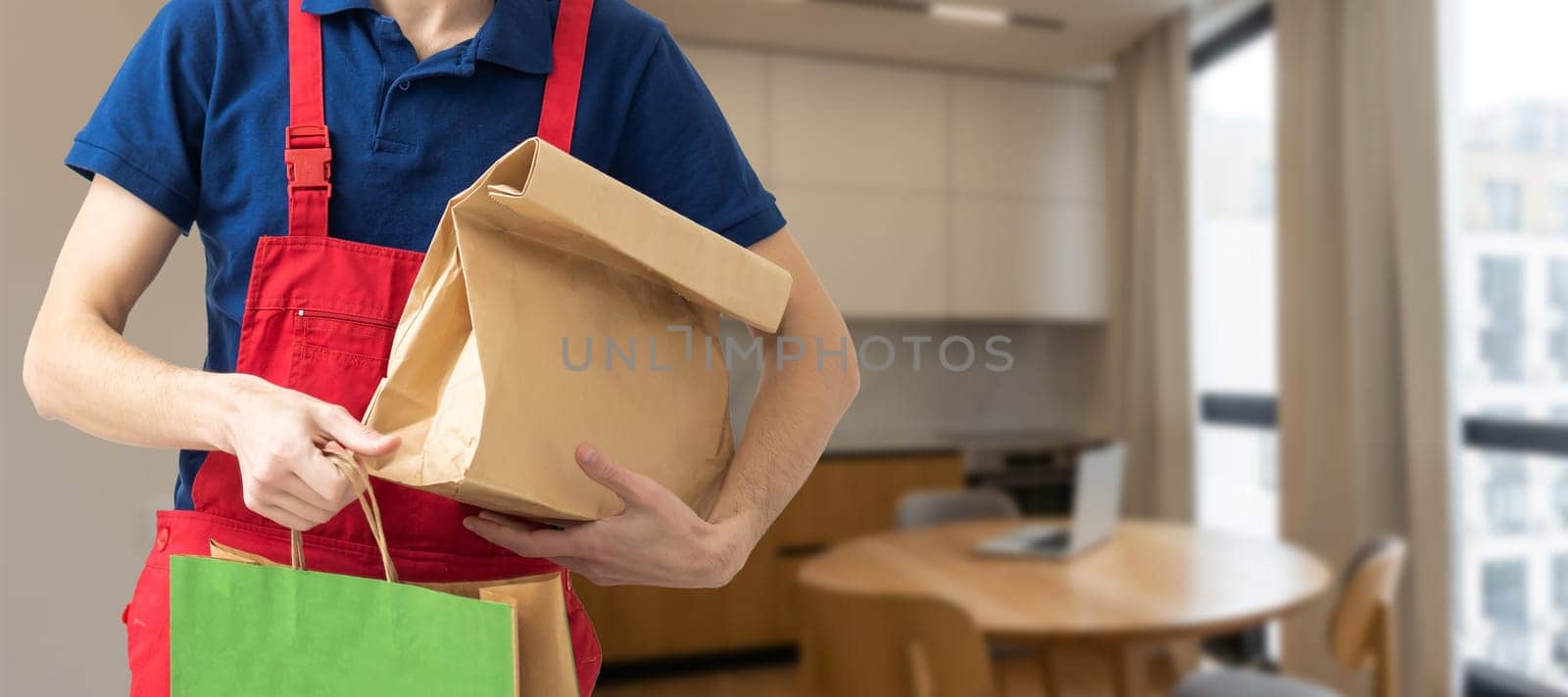 Young handsome man holding delivery paper bag by Andelov13