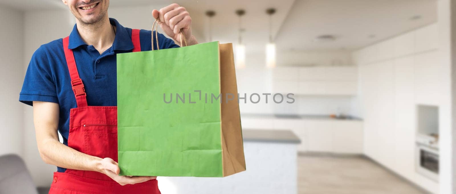 box with fast food being carried by delivery man in uniform for one of clients.