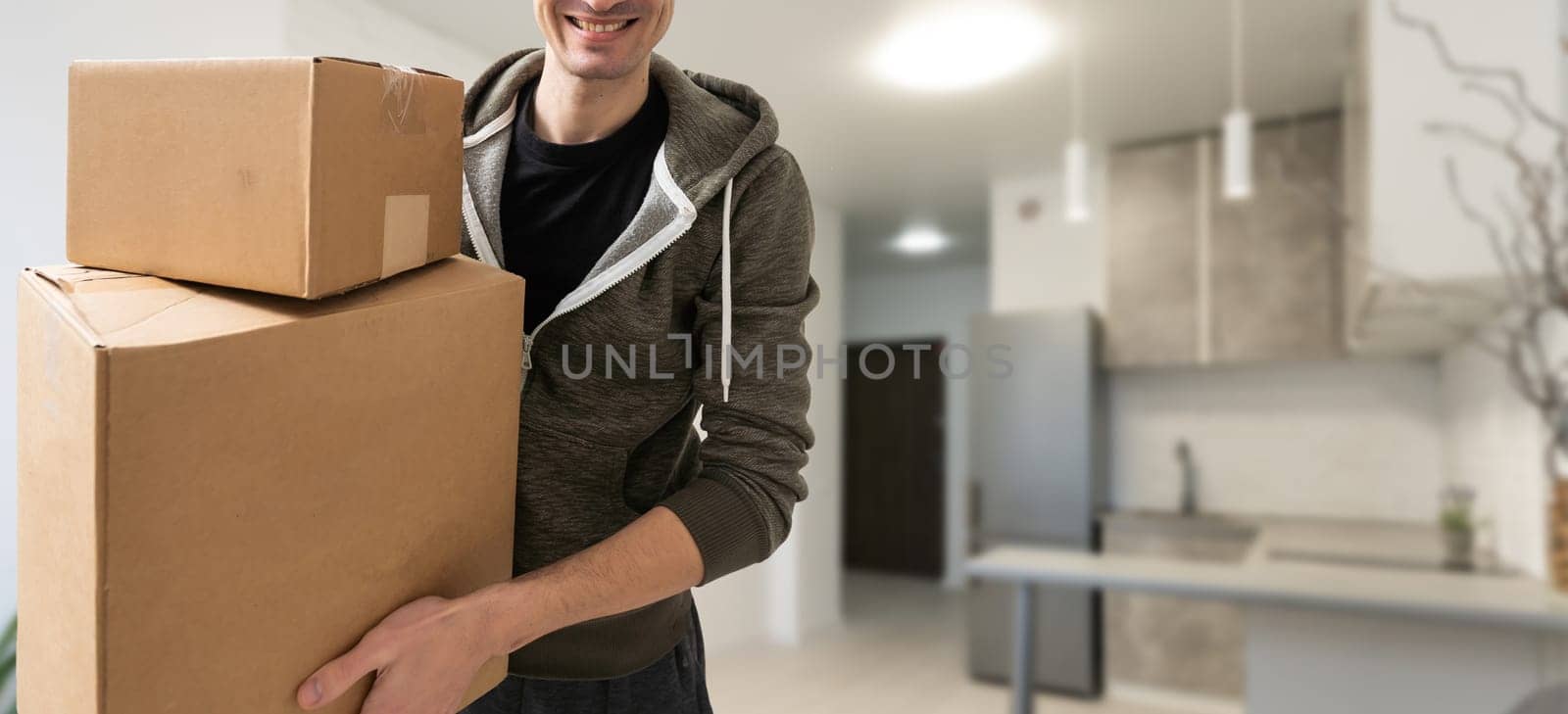 young man carries moving boxes.