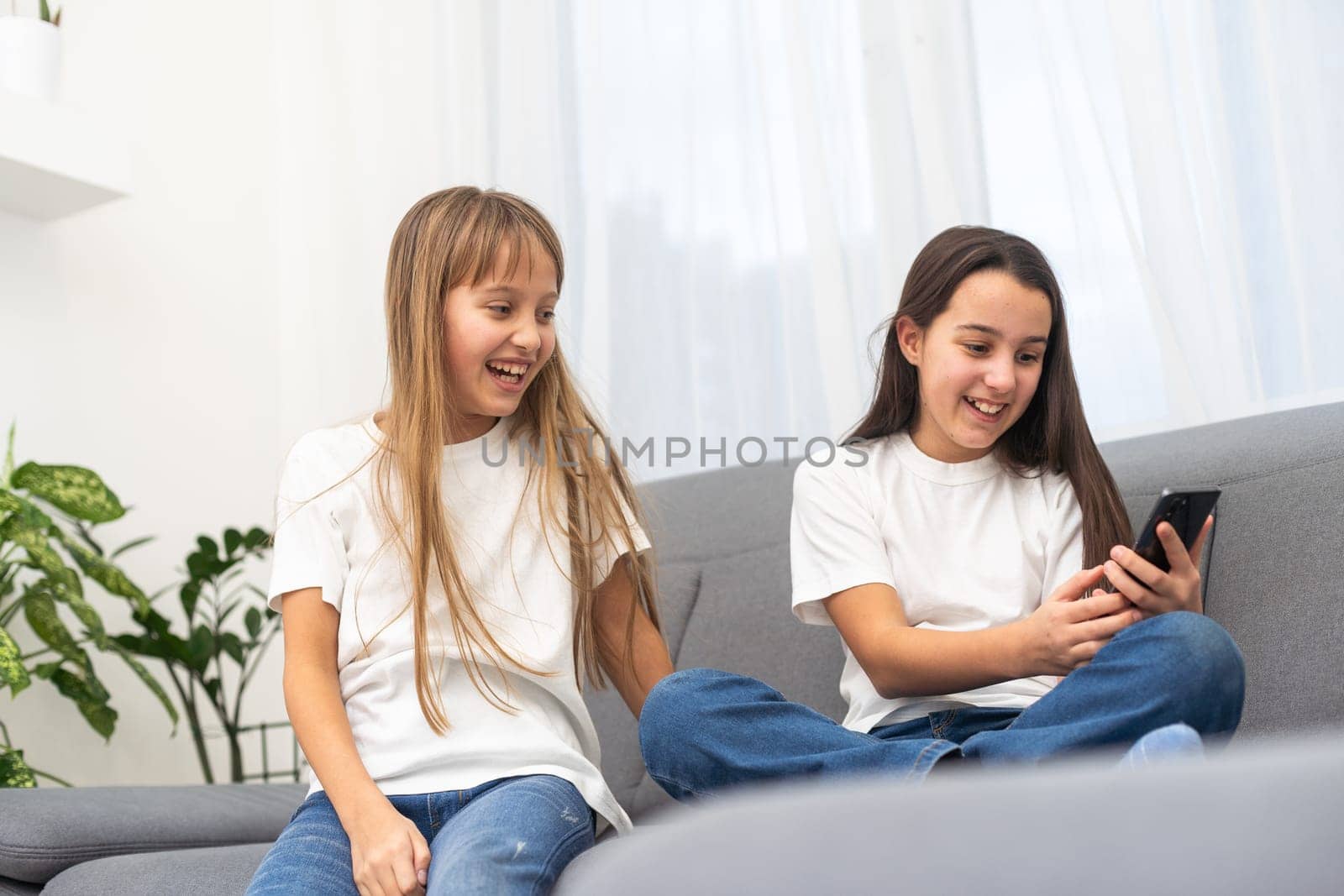 Children play with a mobile phone at home by Andelov13