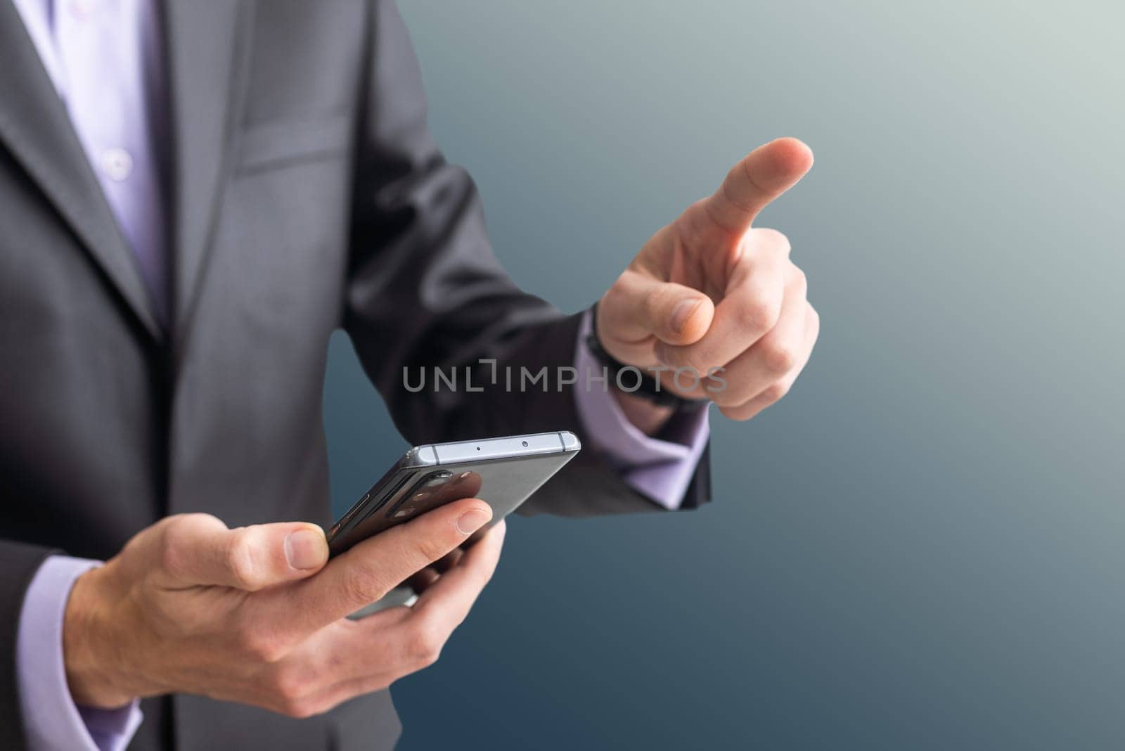 Businessman in the suit is using smartphone by Andelov13