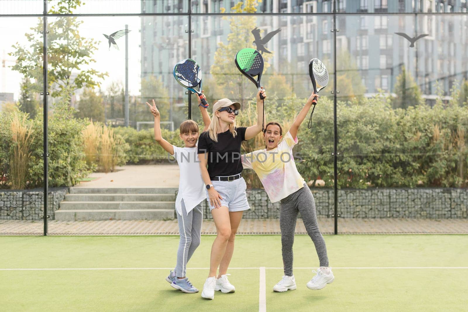 Active young woman practicing Padel Tennis with group of players in the tennis court outdoors. High quality photo