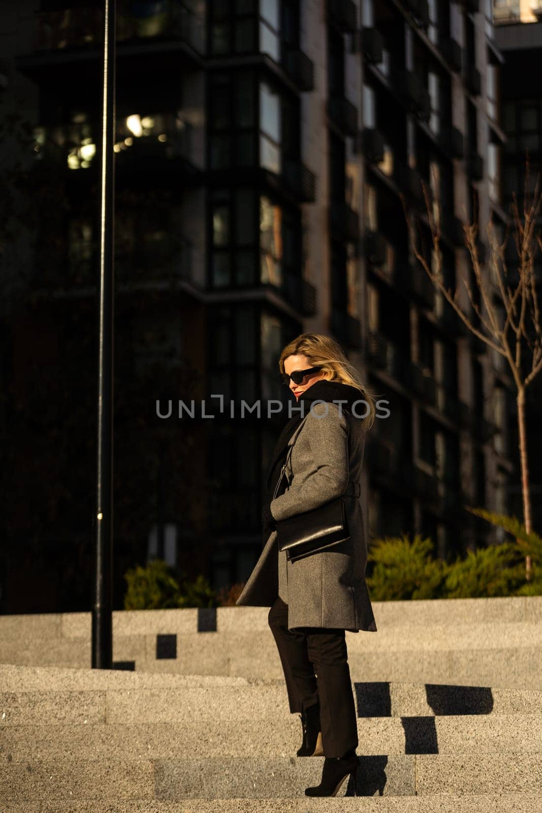 The girl in a coat walks around the city on a sunny day. High quality photo