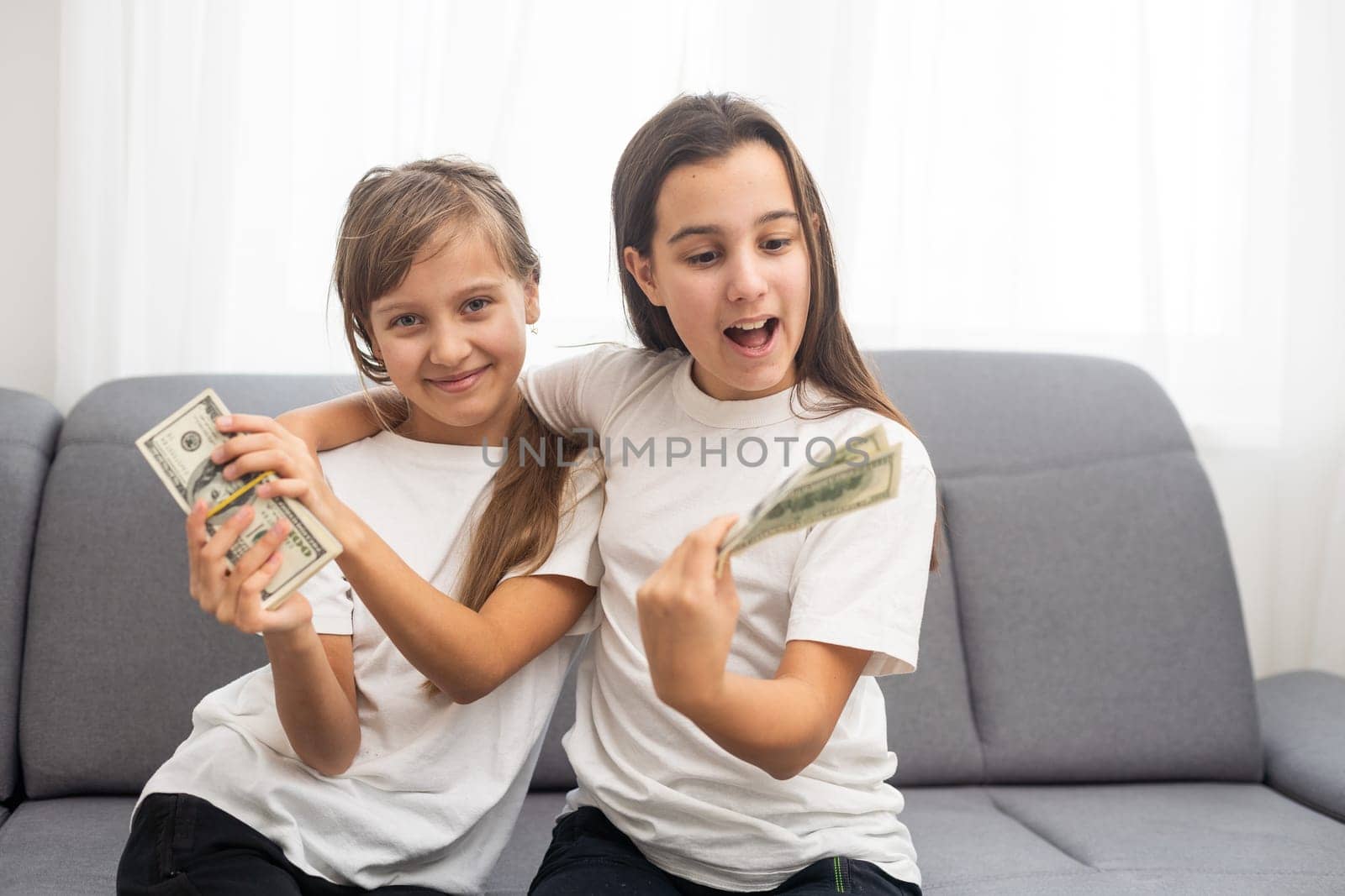 Photo of lucky caucasian girls wearing casual clothing holding fans of dollars in hands. High quality photo