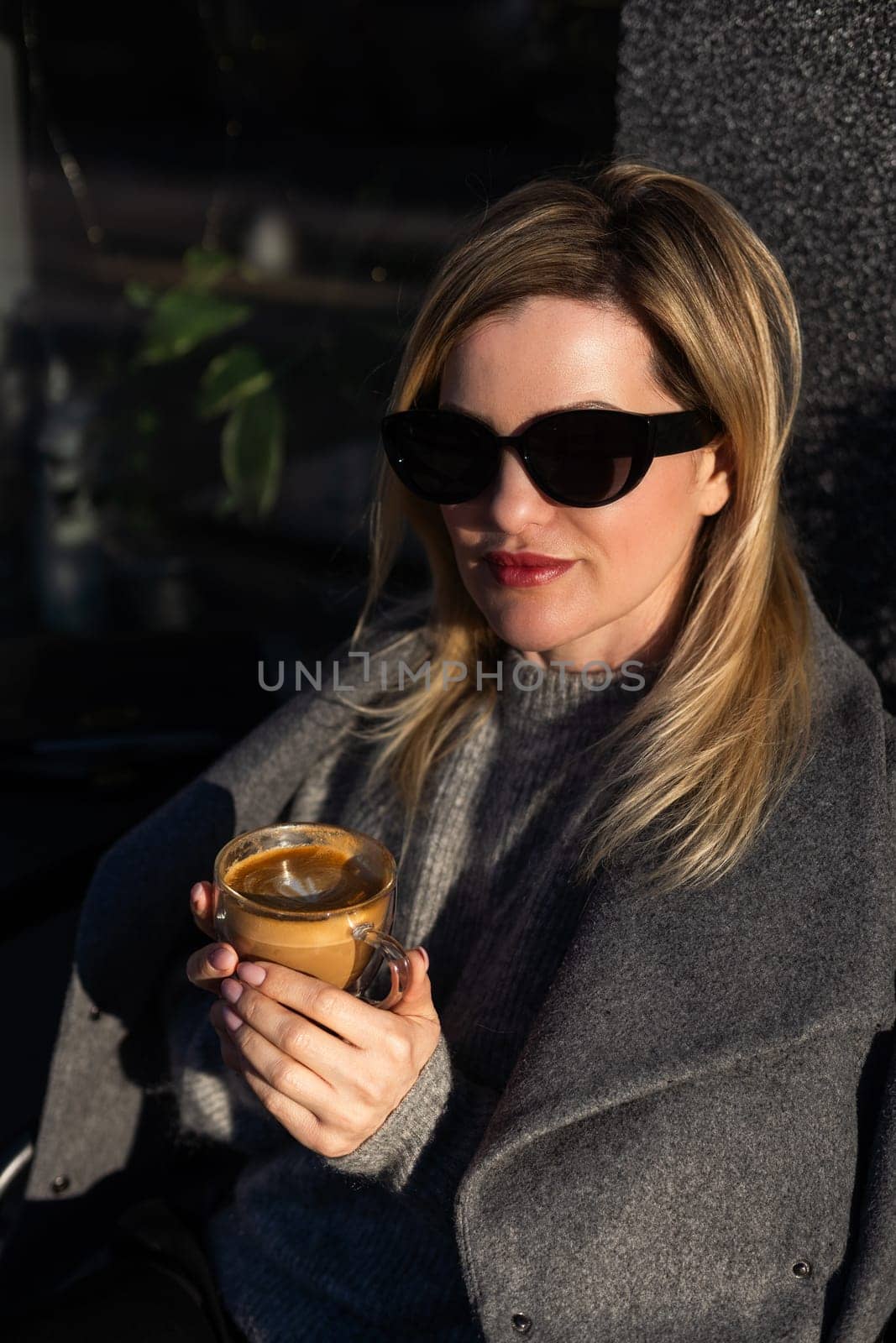 Young beautiful woman sitting in a cafe and drinking a cappuccino. High quality photo