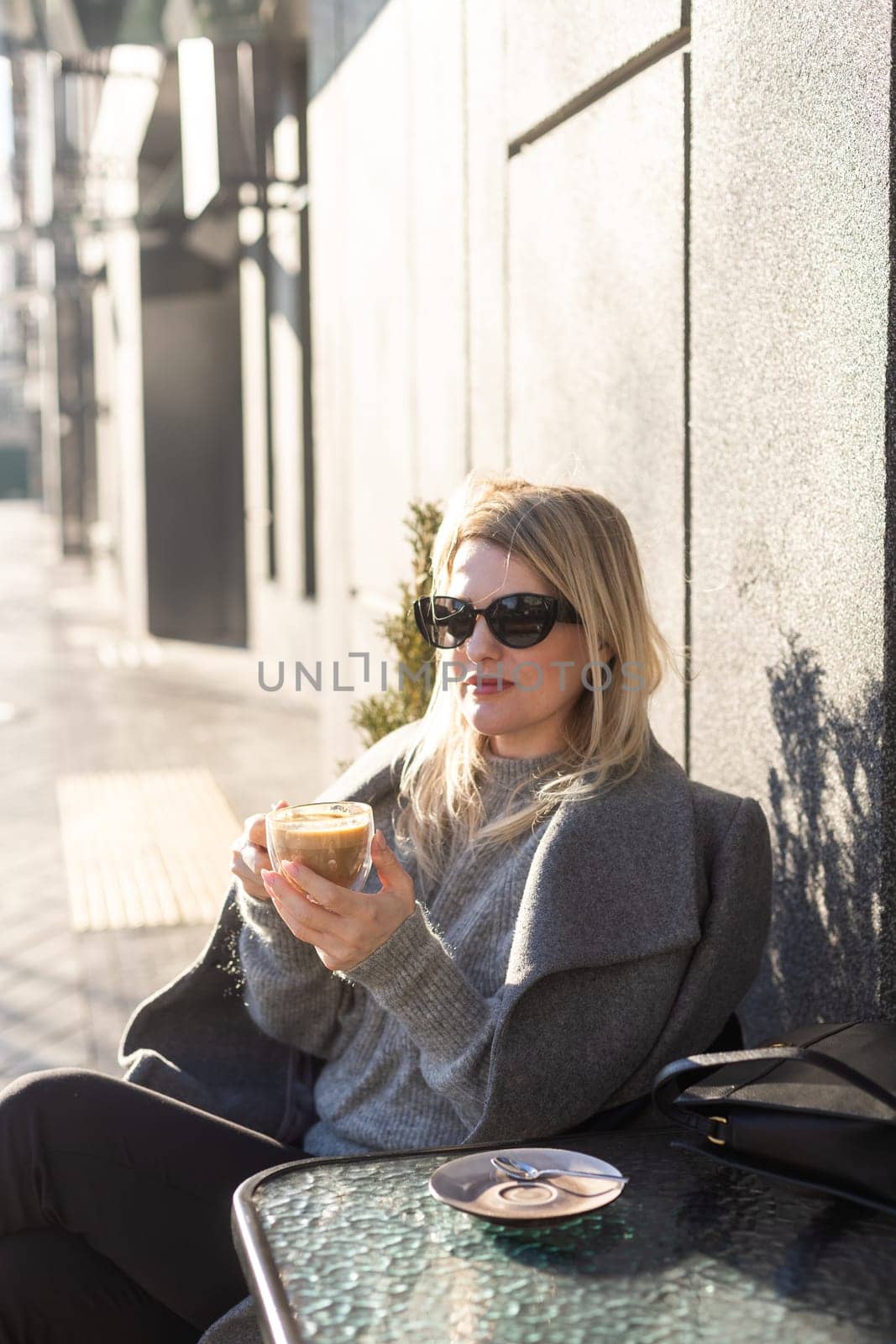 Young beautiful woman sitting in a cafe and drinking a cappuccino. High quality photo