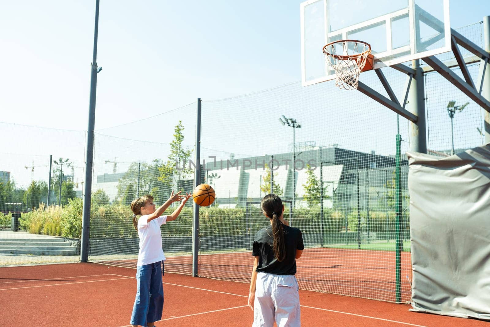Concept of sports, hobbies and healthy lifestyle. Young people playing basketball on playground outdoors by Andelov13