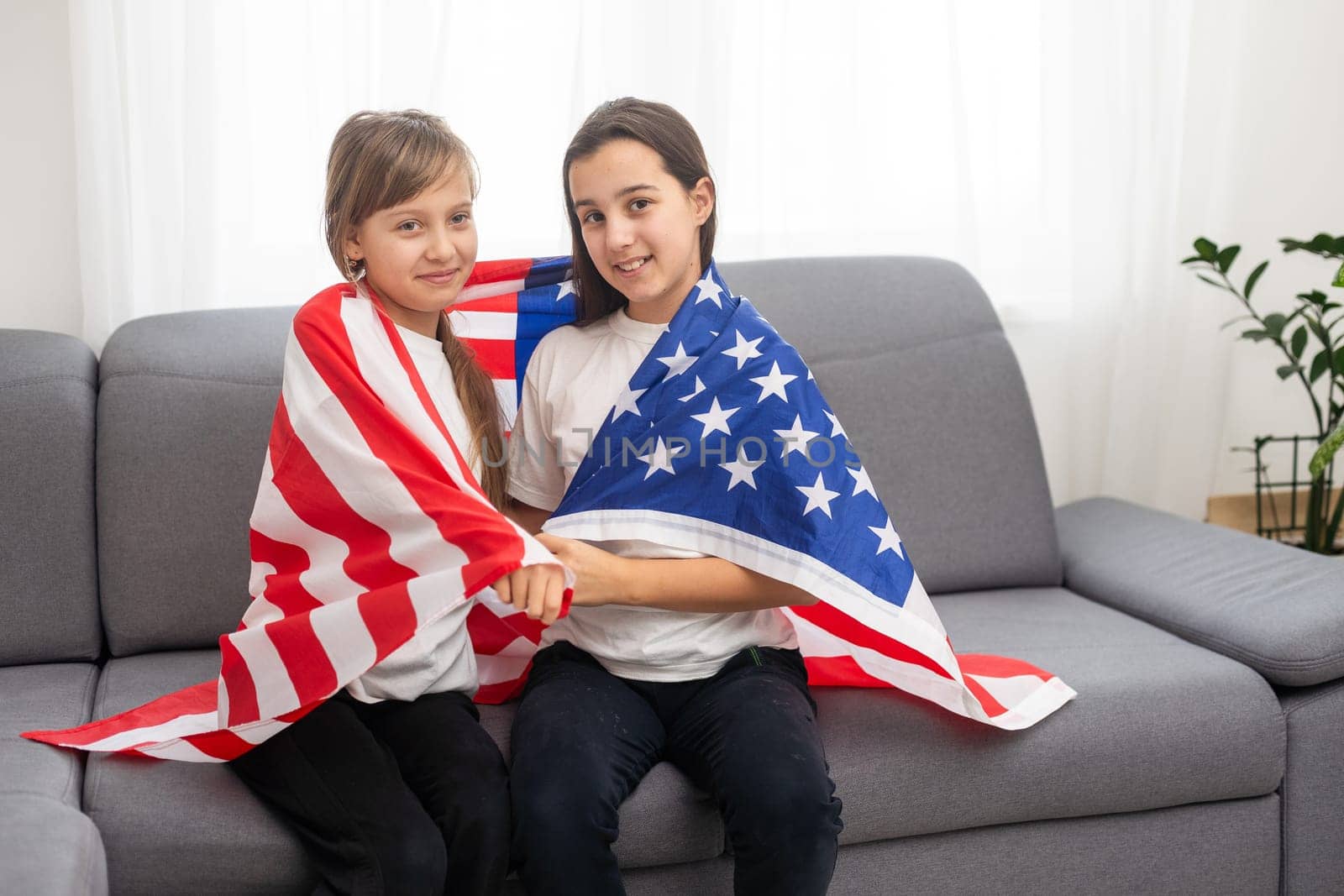 cheerful adorable kids standing under american flag and looking at. High quality photo