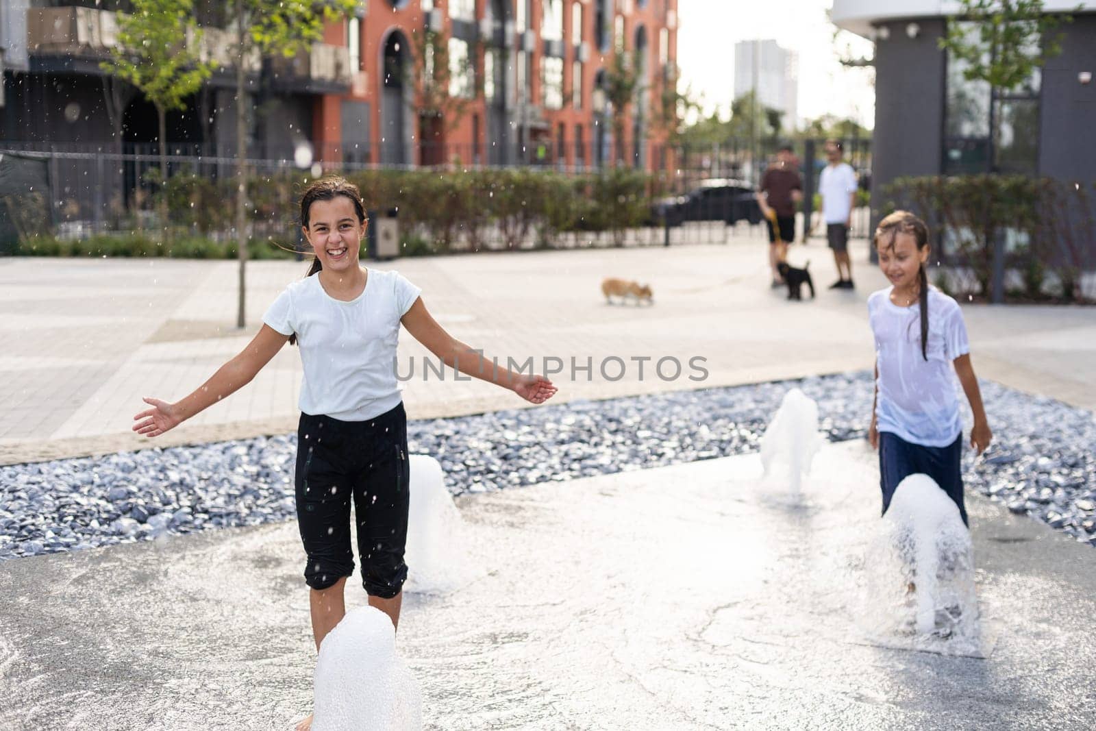 On a hot day, children run and have fun at the city fountain. Leisure time concept. summer holidays. happy childhood. High quality photo