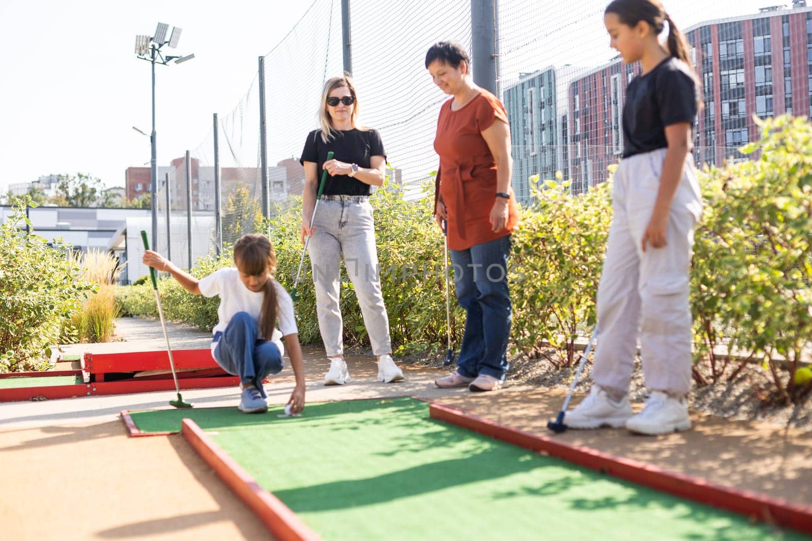 family playing mini golf on a cruise liner. Child having fun with active leisure on vacations. by Andelov13